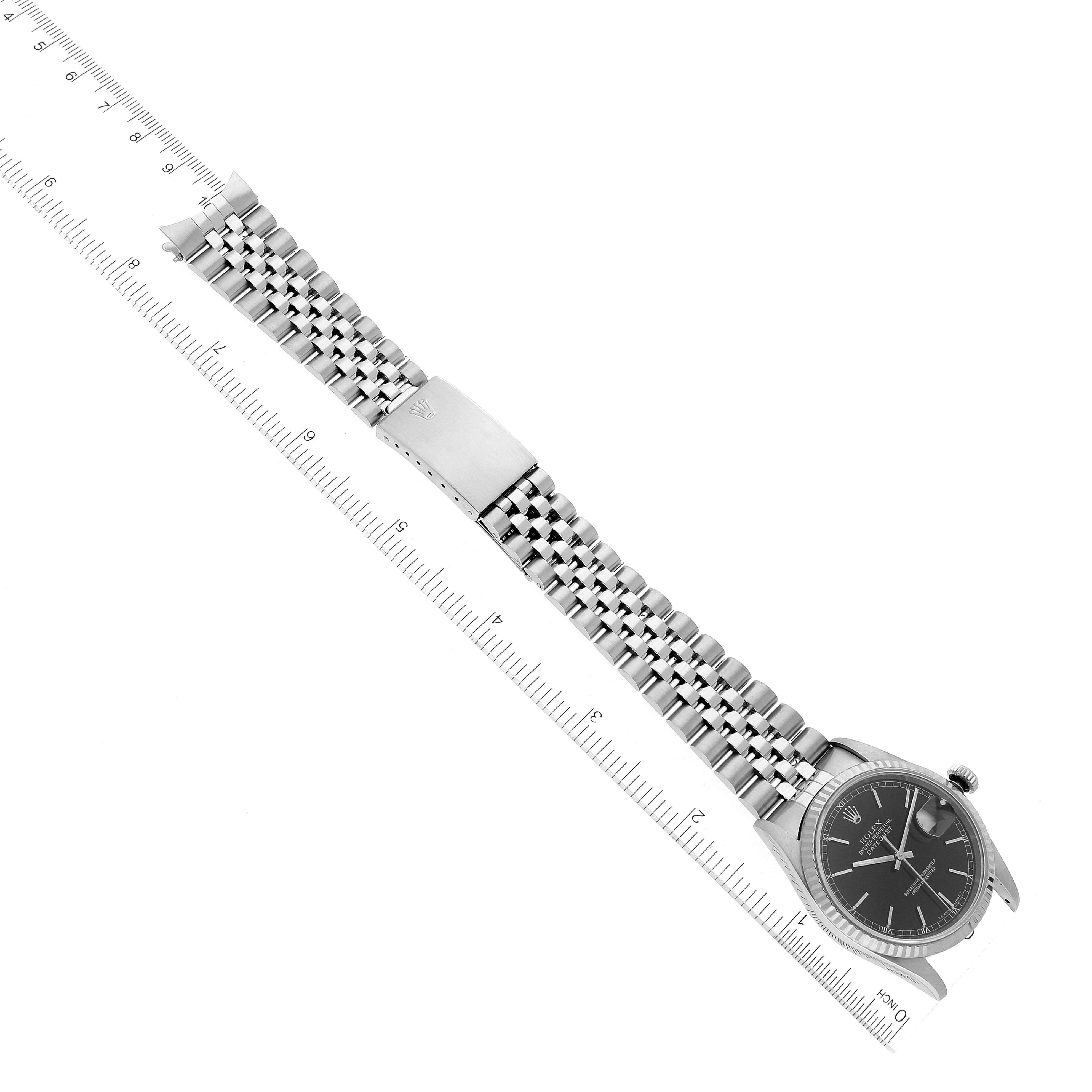 The image shows a Rolex Datejust 16234 Men's Stainless Steel Black Dial 16234 Men's Stainless Steel Black Dial watch placed flat with a ruler for scale, highlighting the bracelet and face.