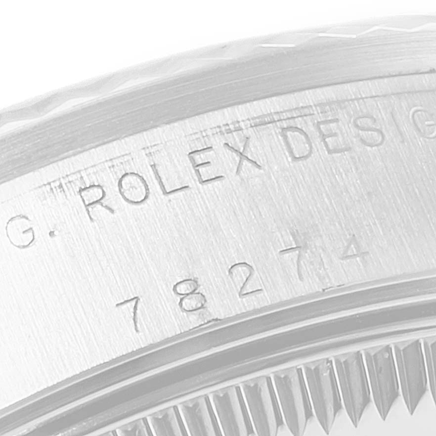 The image shows a close-up angle of the engraving on the side of a Rolex Mid-Size 78274 Women
s Stainless Steel White Dial 78274 Women
s Stainless Steel White Dial watch case, displaying the brand and part of the serial number.