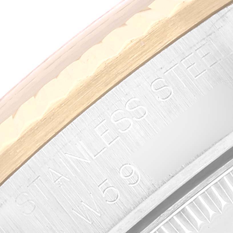 This close-up image shows the engraved edge and bezel of a Mid-Size Rolex watch, highlighting the stainless steel and gold materials.