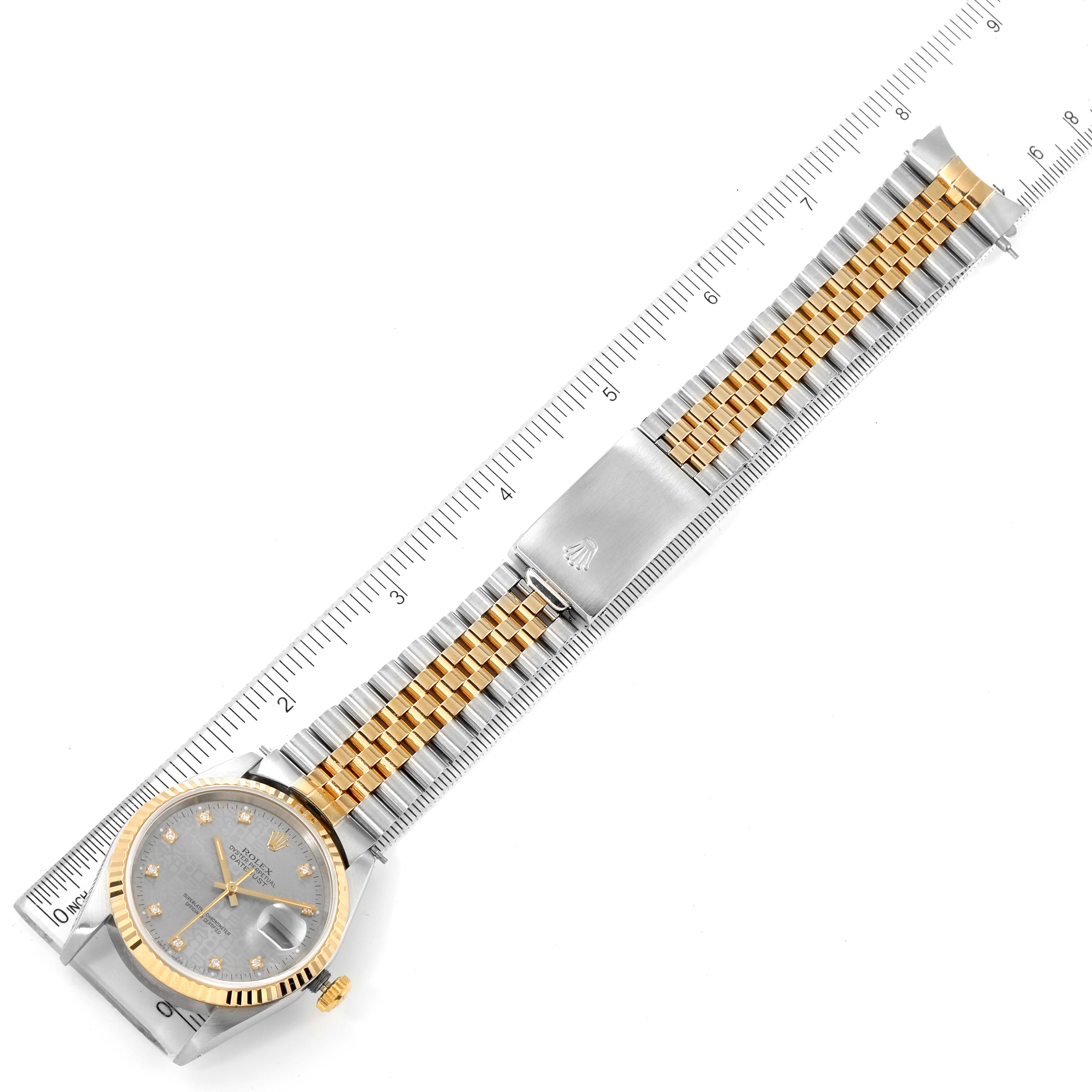 This image shows a top-down view of a Rolex Datejust 16233 Men
s Steel and Gold (two tone) Grey Dial 16233 Men
s Steel and Gold (two tone) Grey Dial watch with a ruler for scale.