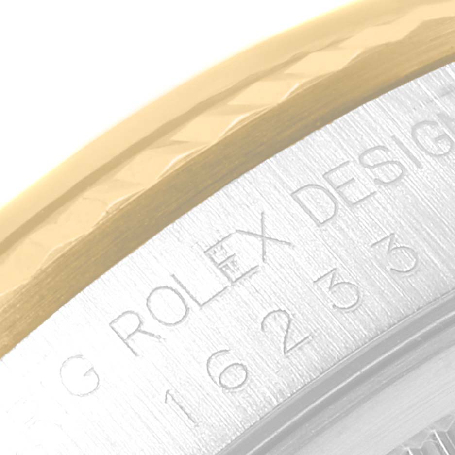 This close-up image of a Rolex Datejust 16233 Men
s Steel and Gold (two tone) Grey Dial 16233 Men
s Steel and Gold (two tone) Grey Dial watch shows the edge of the bezel and part of the engraved case back.