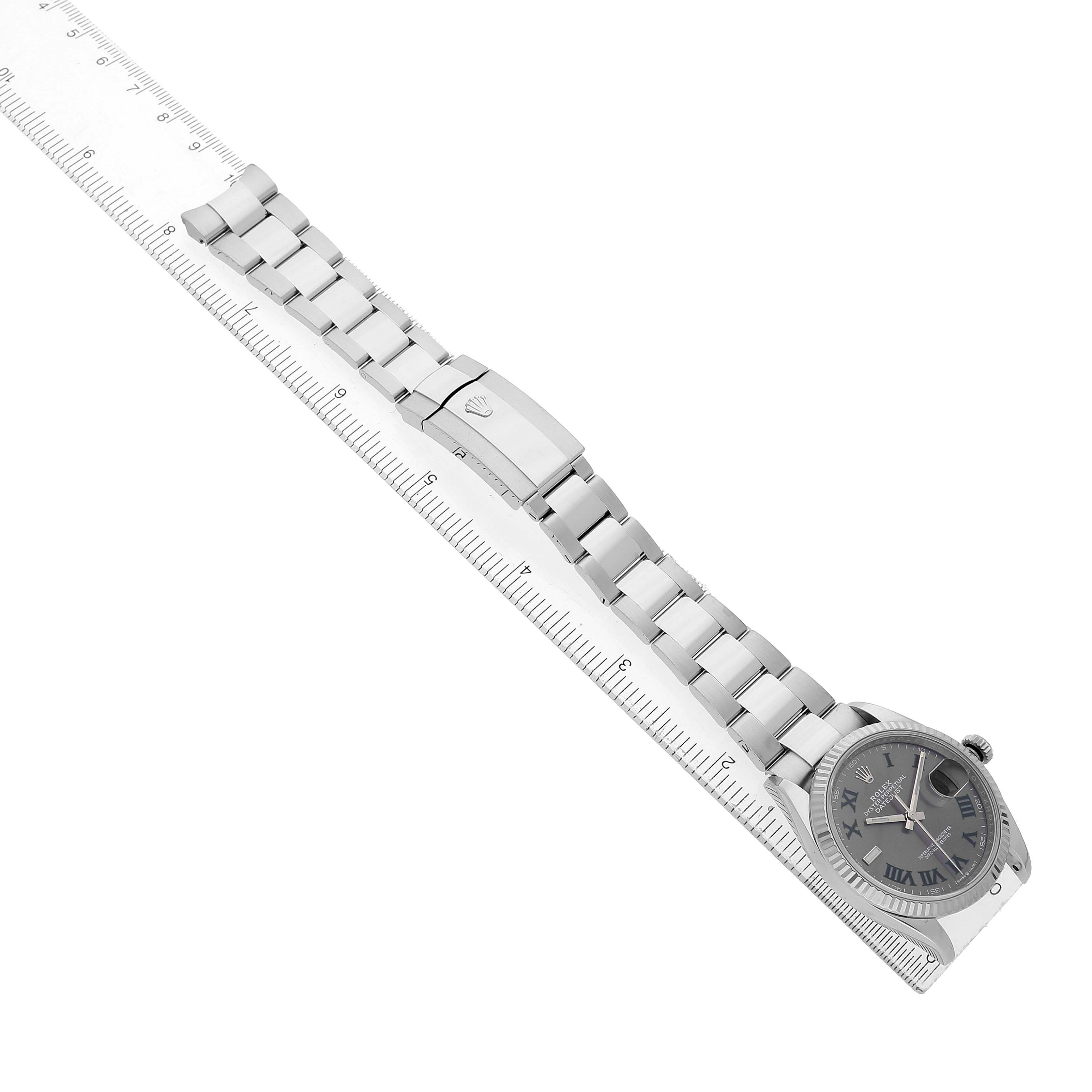 The Rolex Datejust 126234 Men's Stainless Steel Grey Dial watch is shown laid flat alongside a ruler, displaying the full bracelet, clasp, and watch face.