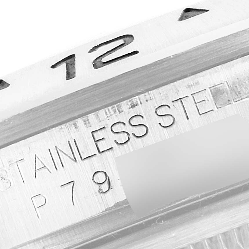 The image shows a close-up of the bezel and case of a Rolex Explorer 16570 Men
s Stainless Steel White Dial 16570 Men
s Stainless Steel White Dial watch, highlighting the "12" marker, "STAINLESS STEEL" engraving, and part number.