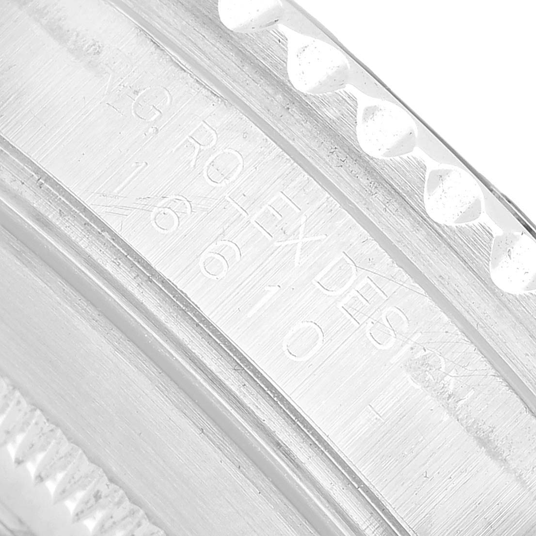 The image shows a close-up of the Rolex Submariner 16610 Men's Stainless Steel Black Dial's case edge and engraved text.