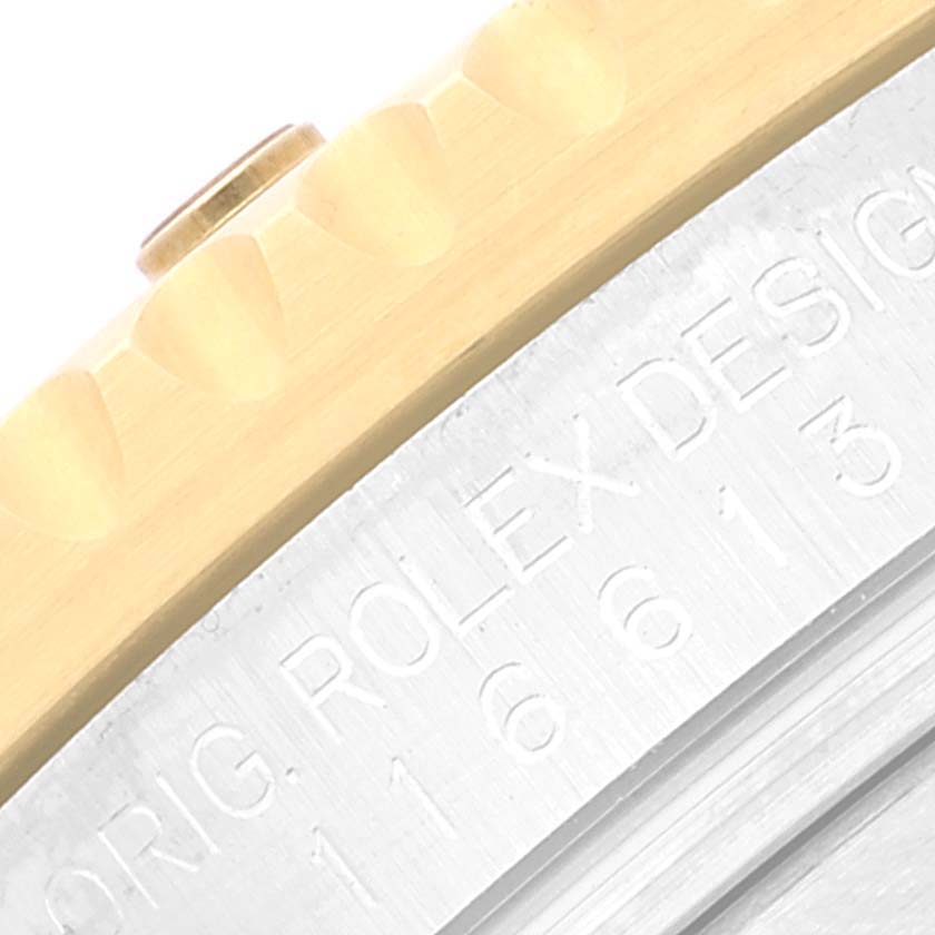 This image shows a close-up of the engraved side of a Rolex Submariner 116613 Men's Steel and Gold (two tone) Blue Dial 116613 Men's Steel and Gold (two tone) Blue Dial watch, including the bezel and part of the case.