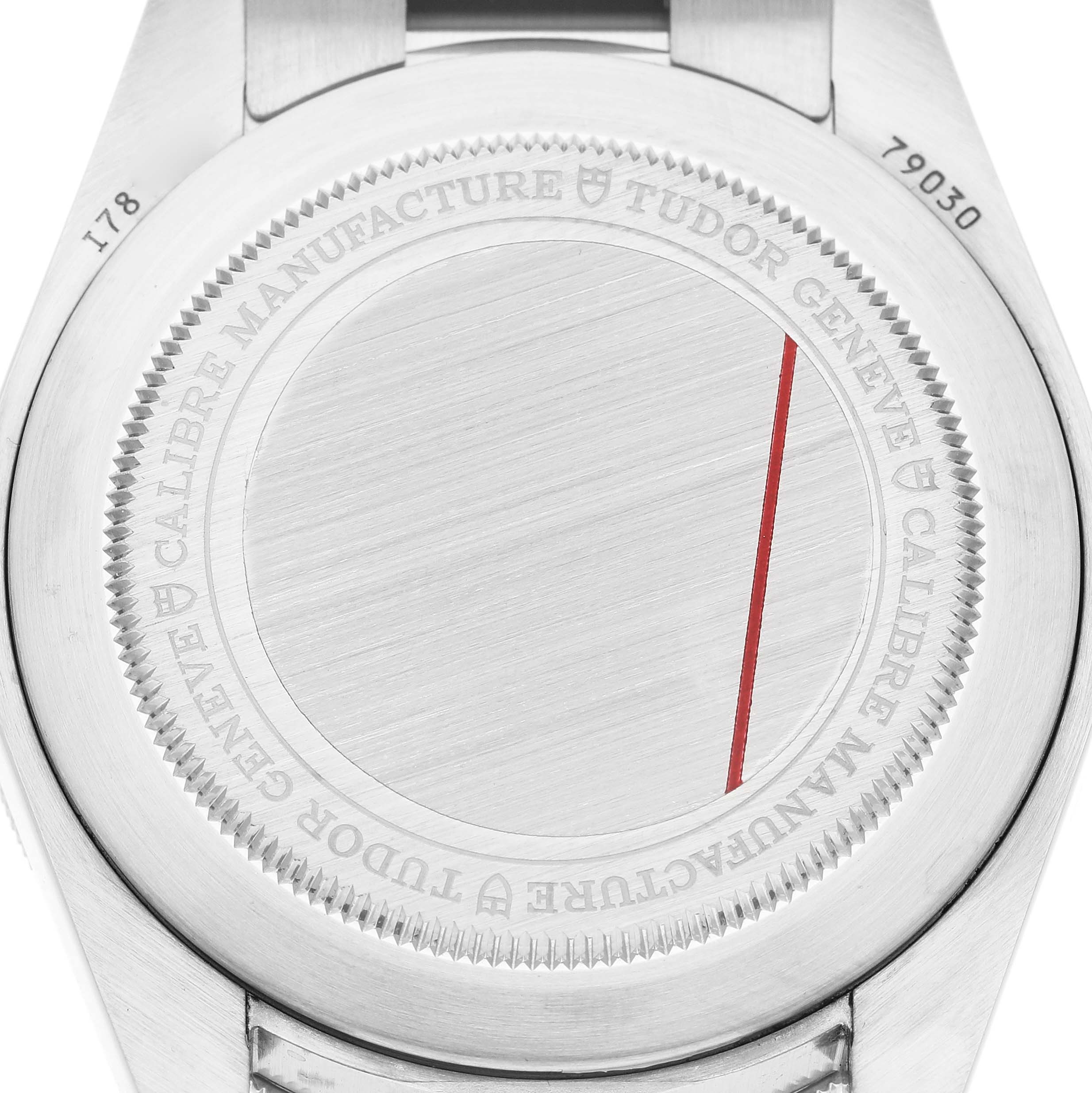 The image shows the back case of a Tudor Heritage Black Bay 79030 Men's Stainless Steel Black Dial watch, displaying engravings and a red line.
