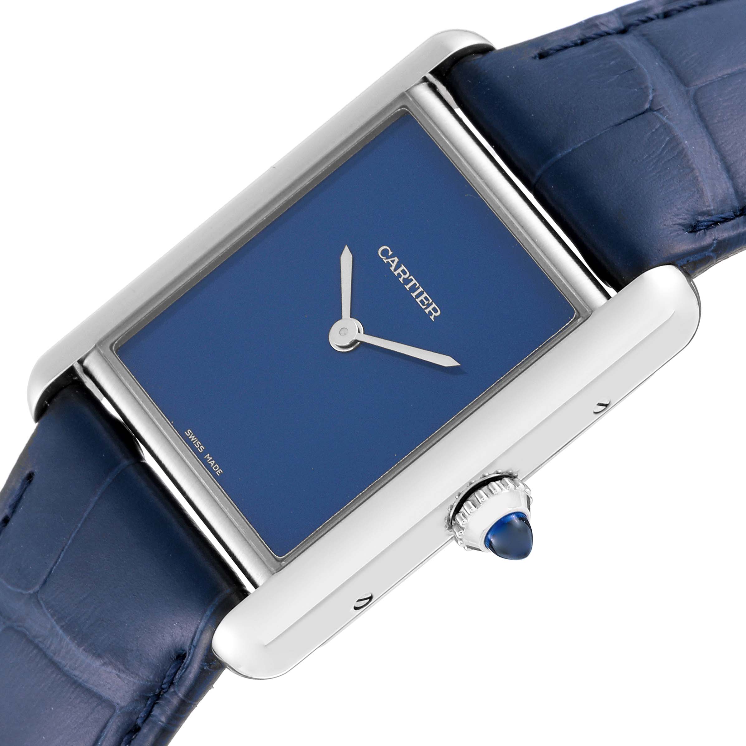 The image shows a Cartier Tank Must WSTA0055 Women
s Stainless Steel Blue Dial WSTA0055 Women
s Stainless Steel Blue Dial watch from an oblique angle highlighting the blue dial, crown, and part of the blue strap.