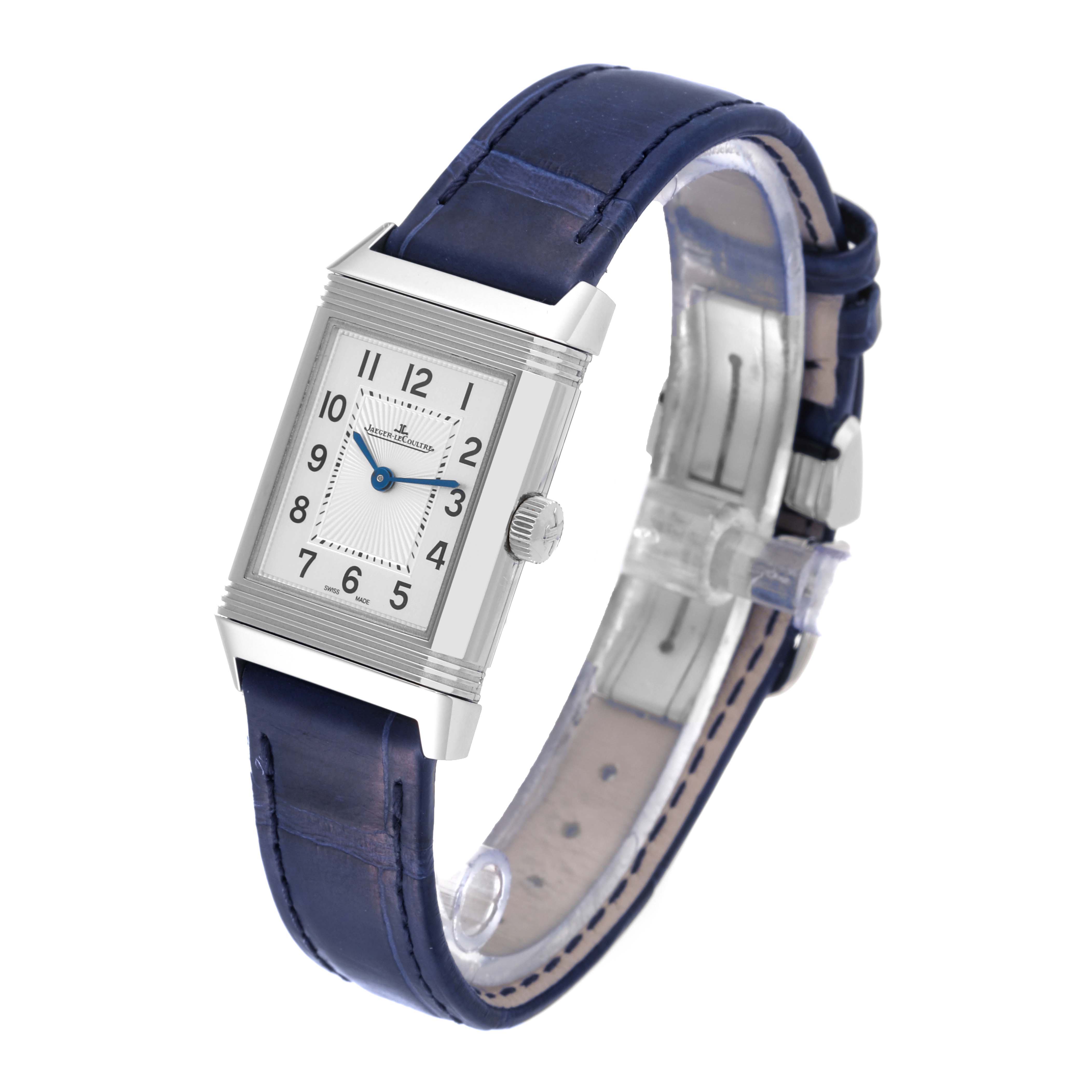The image shows a Jaeger-LeCoultre Reverso watch positioned at a front-left angle, displaying its face and blue leather strap.