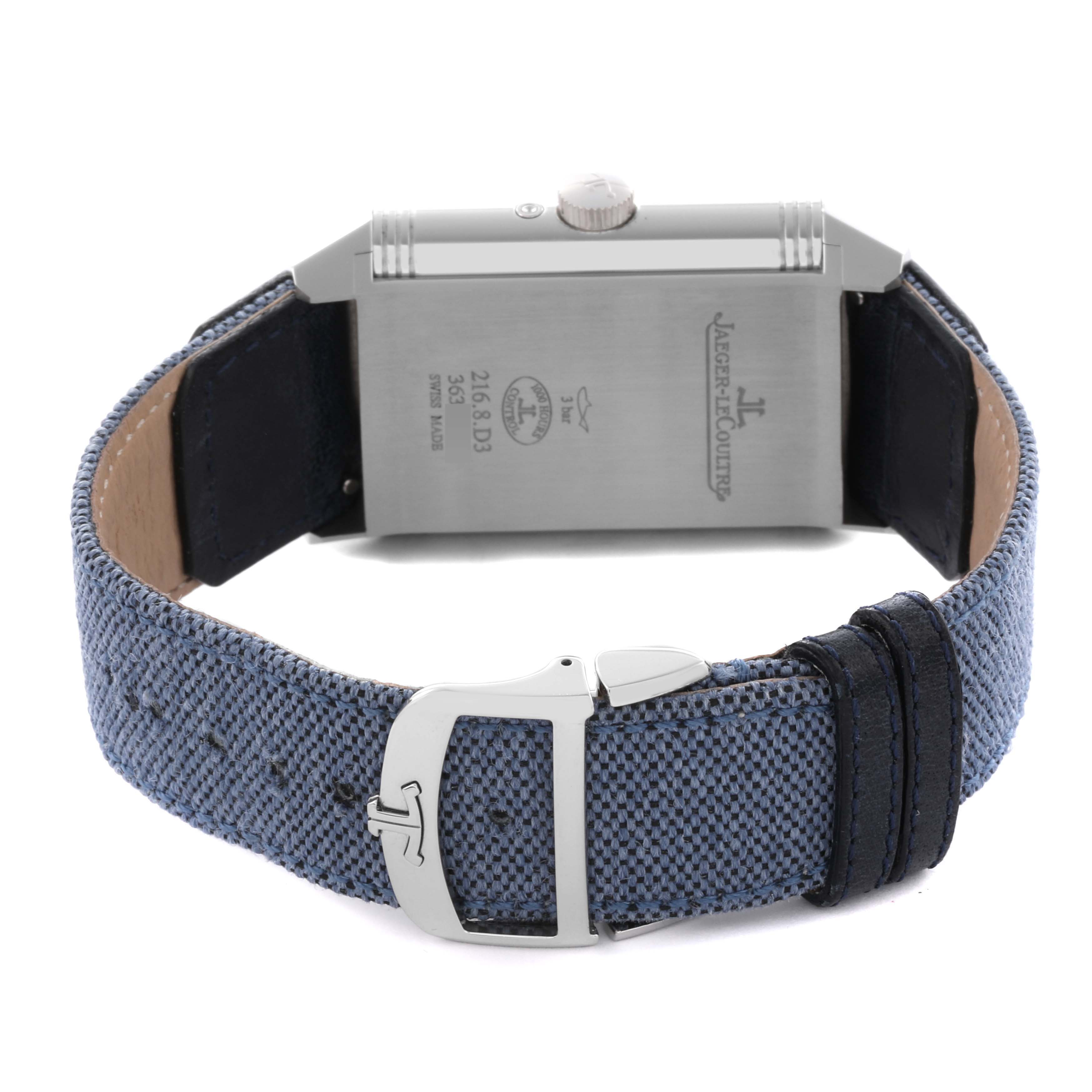 The Jaeger-LeCoultre Reverso watch is shown from the back, featuring the case back, crown, and textured strap with buckle.