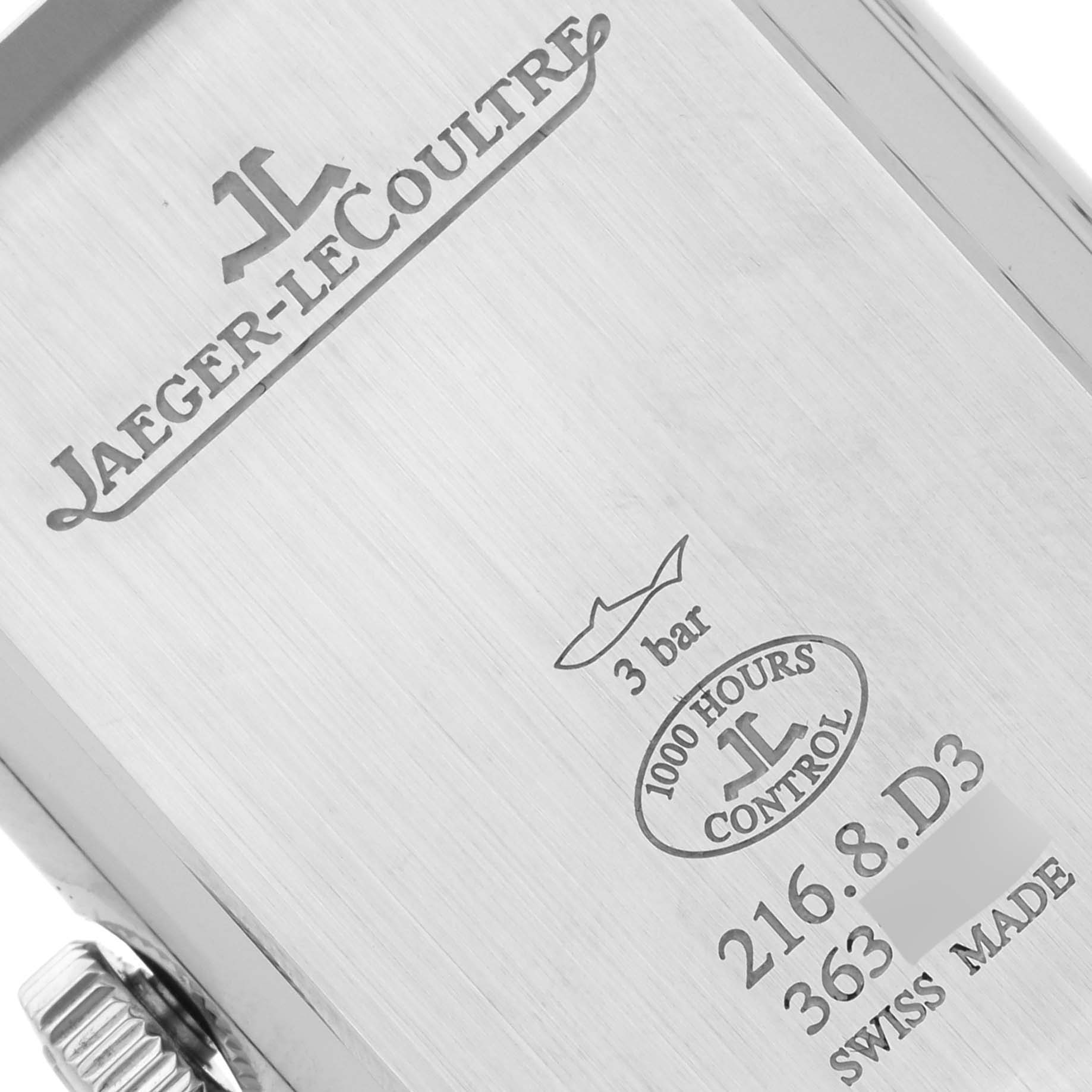 The image shows the back of the Jaeger-LeCoultre Reverso watch, highlighting the engravings and the crown from an angled perspective.