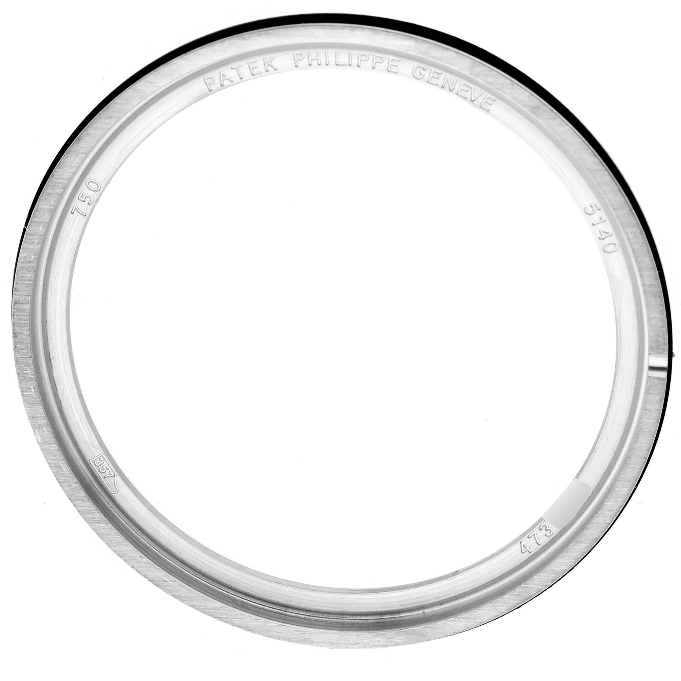 The image shows a front view of the bezel for a Patek Philippe Complications 5140G-001 Men's White Gold Silver Dial 5140G-001 Men's White Gold Silver Dial model, featuring engraved branding details.