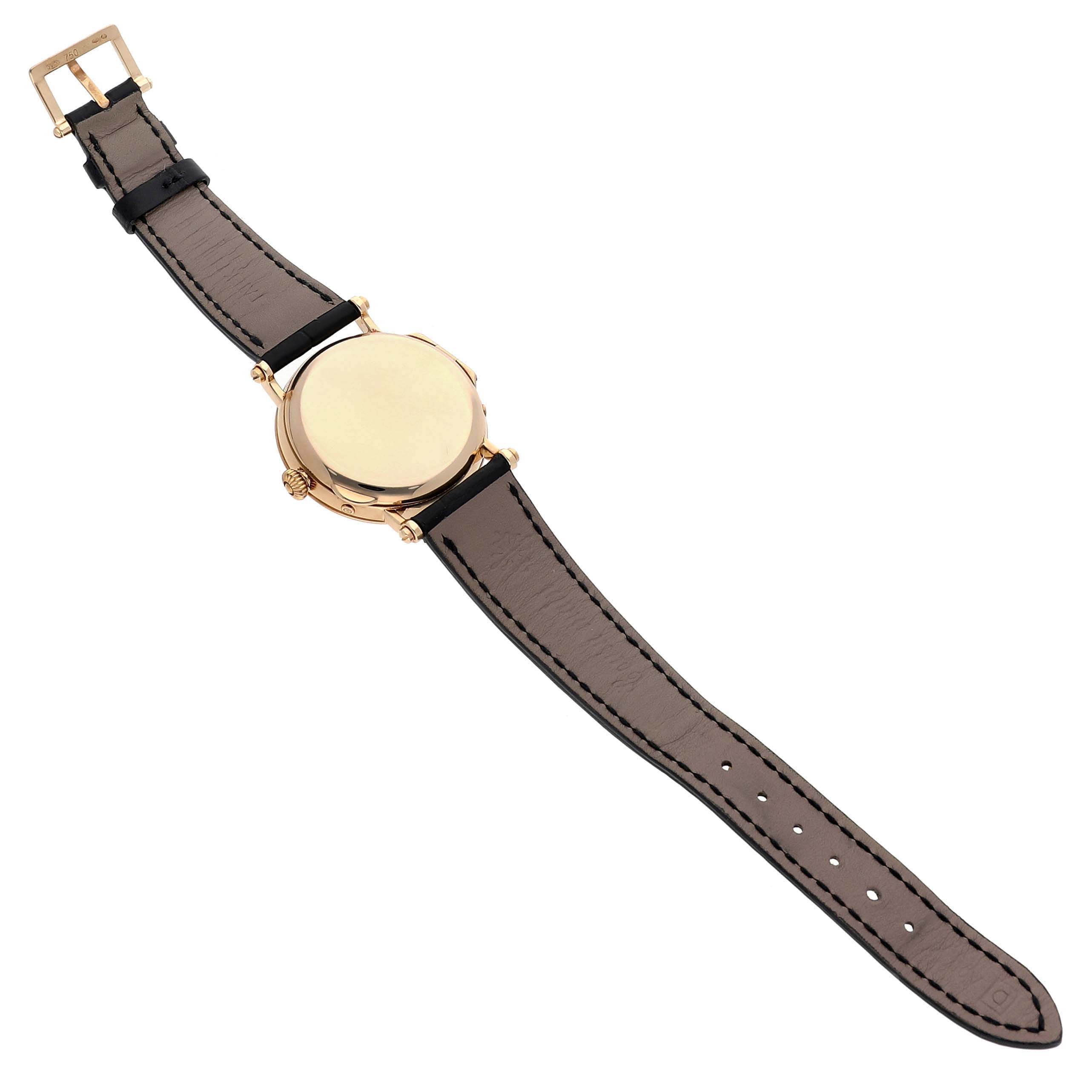 The image shows the back view of a Patek Philippe Complications 5054 Men's Yellow Gold White Dial watch, displaying its strap, buckle, and case back.