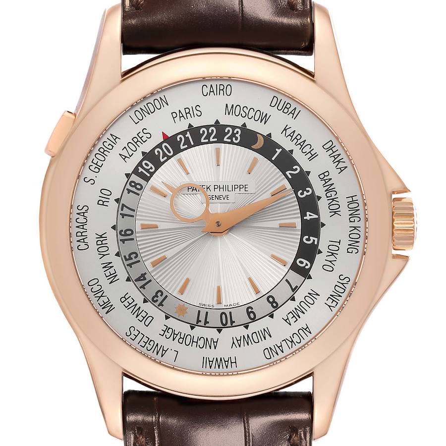 The Patek Philippe Complications watch is shown from the front, displaying its world time dial and brown leather strap.