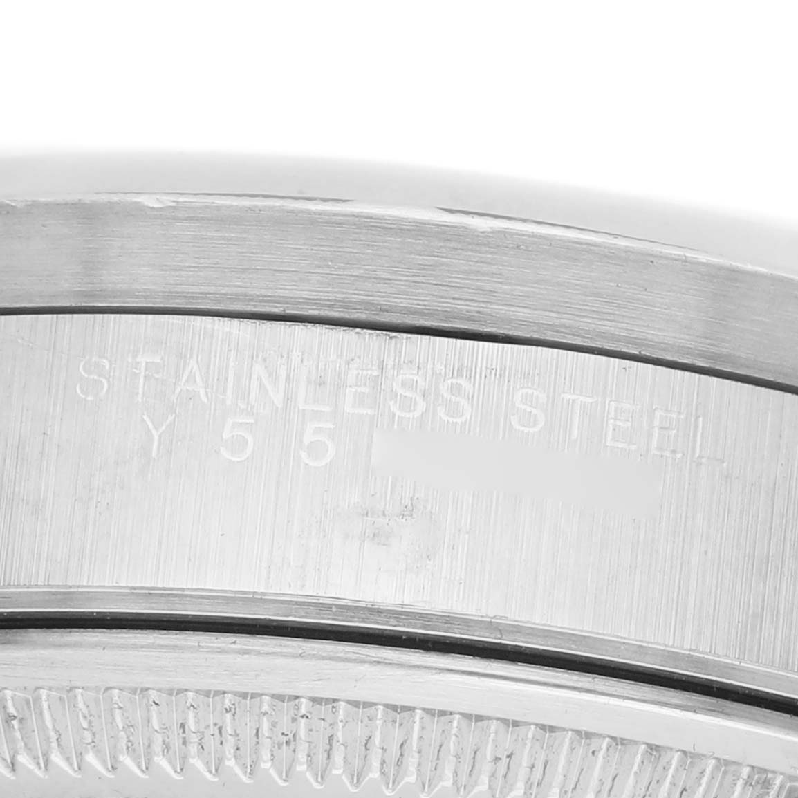 The image shows a close-up of the case edge of a Rolex Date 15210 Men's Stainless Steel Black Dial model, highlighting the stainless steel engraving.