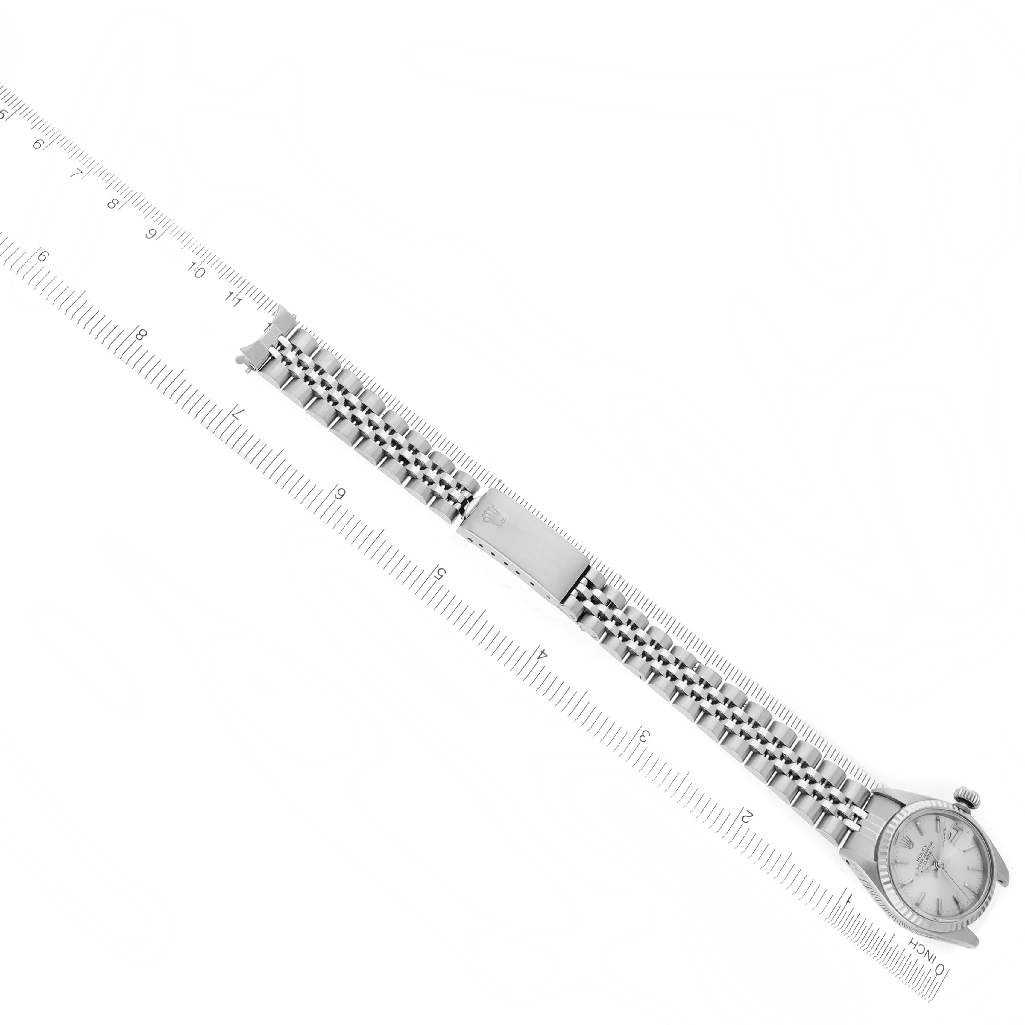 The Rolex Date 6917 Women's Stainless Steel Silver Dial 6917 Women's Stainless Steel Silver Dial watch is shown from a top-down angle, displaying the bracelet, clasp, and watch face alongside a ruler.