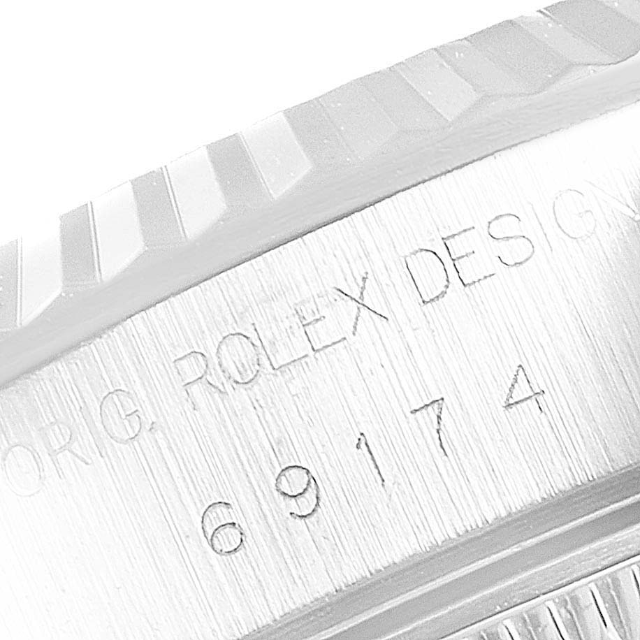 The image shows a close-up of the engraved text and fluted bezel on a Rolex Datejust 69174 Women's Stainless Steel Pink Dial 69174 Women's Stainless Steel Pink Dial watch.