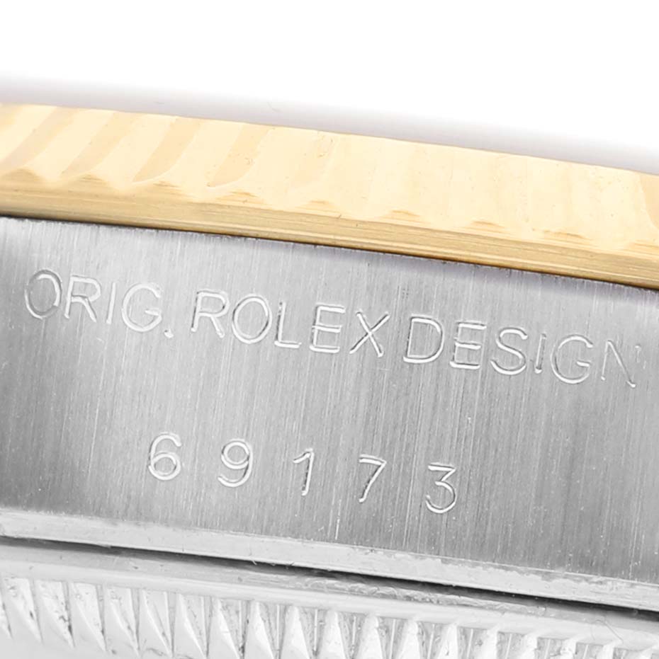 The image shows a close-up of the case side of a Rolex Datejust 69173 Women's Steel and Gold (two tone) Champagne Dial, highlighting the branding and model number engraving.
