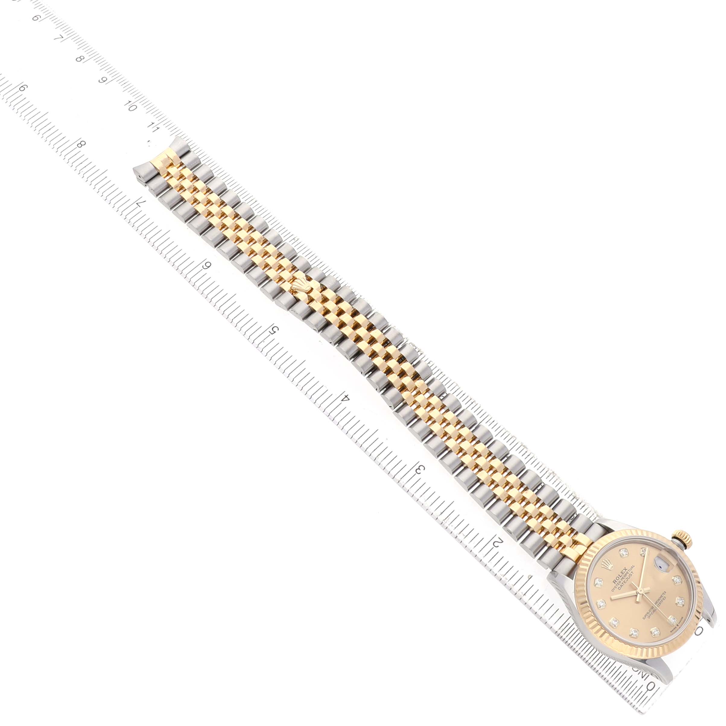 The Rolex Mid-Size 278273 Women's Steel and Gold (two tone) Champagne Dial watch is shown from an overhead angle, featuring the face, dial, and bracelet alongside a ruler for scale.