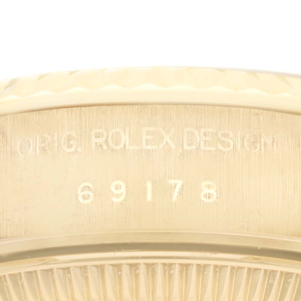 The image shows a close-up of the engraving on the side of the bezel of a Rolex President 69178 Women's Yellow Gold Champagne Dial 69178 Women's Yellow Gold Champagne Dial model watch.