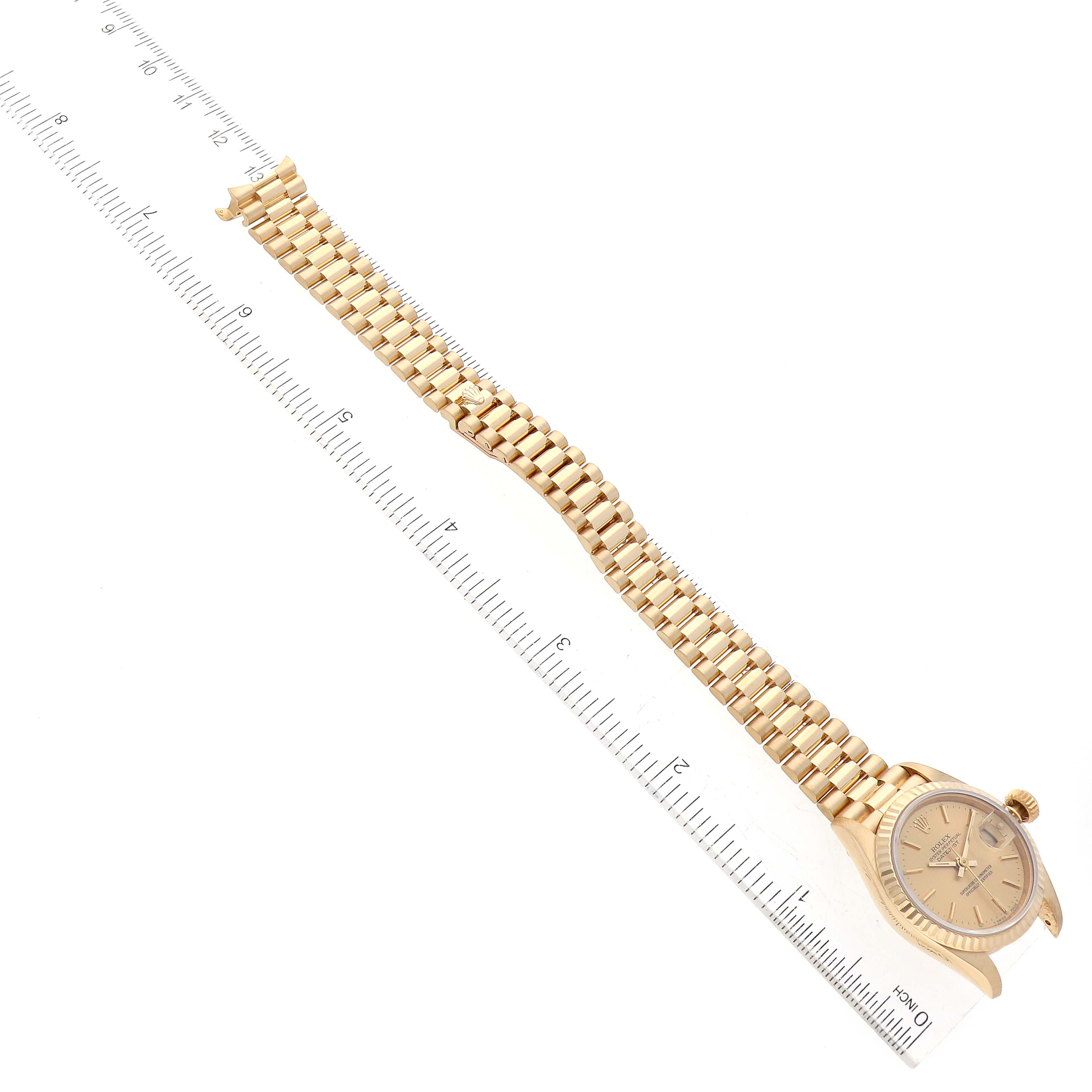 The image shows the Rolex President 69178 Women's Yellow Gold Champagne Dial 69178 Women's Yellow Gold Champagne Dial watch at a top-down angle, displaying the face and fully extended bracelet next to a ruler.