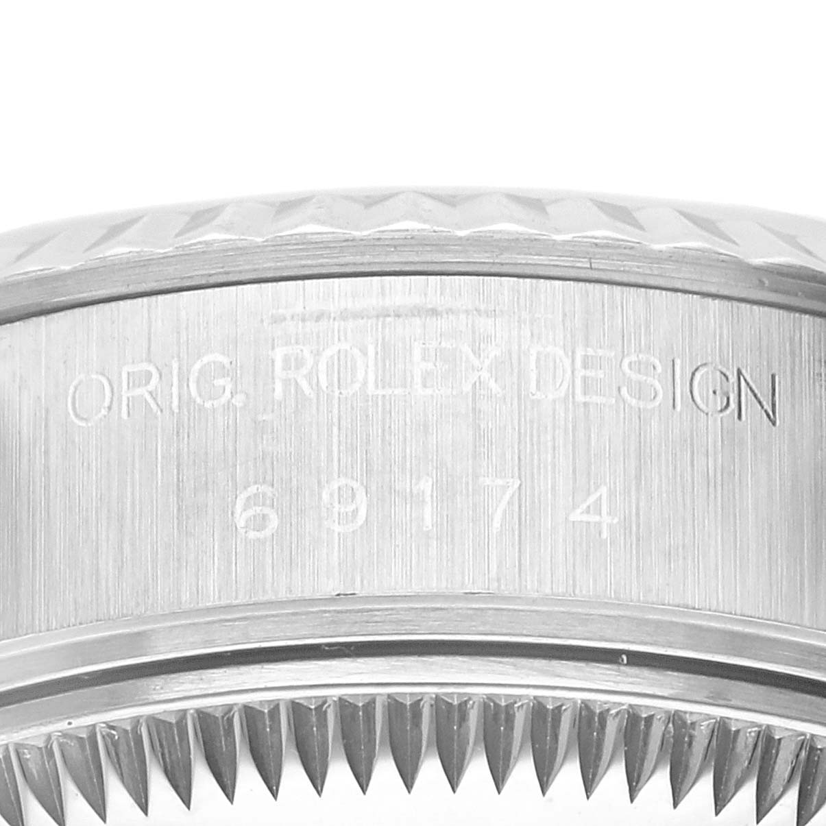 The image shows an up-close view of the side engraving and fluted bezel of a Rolex Datejust 69174 Women's Stainless Steel Silver Dial 69174 Women's Stainless Steel Silver Dial watch.