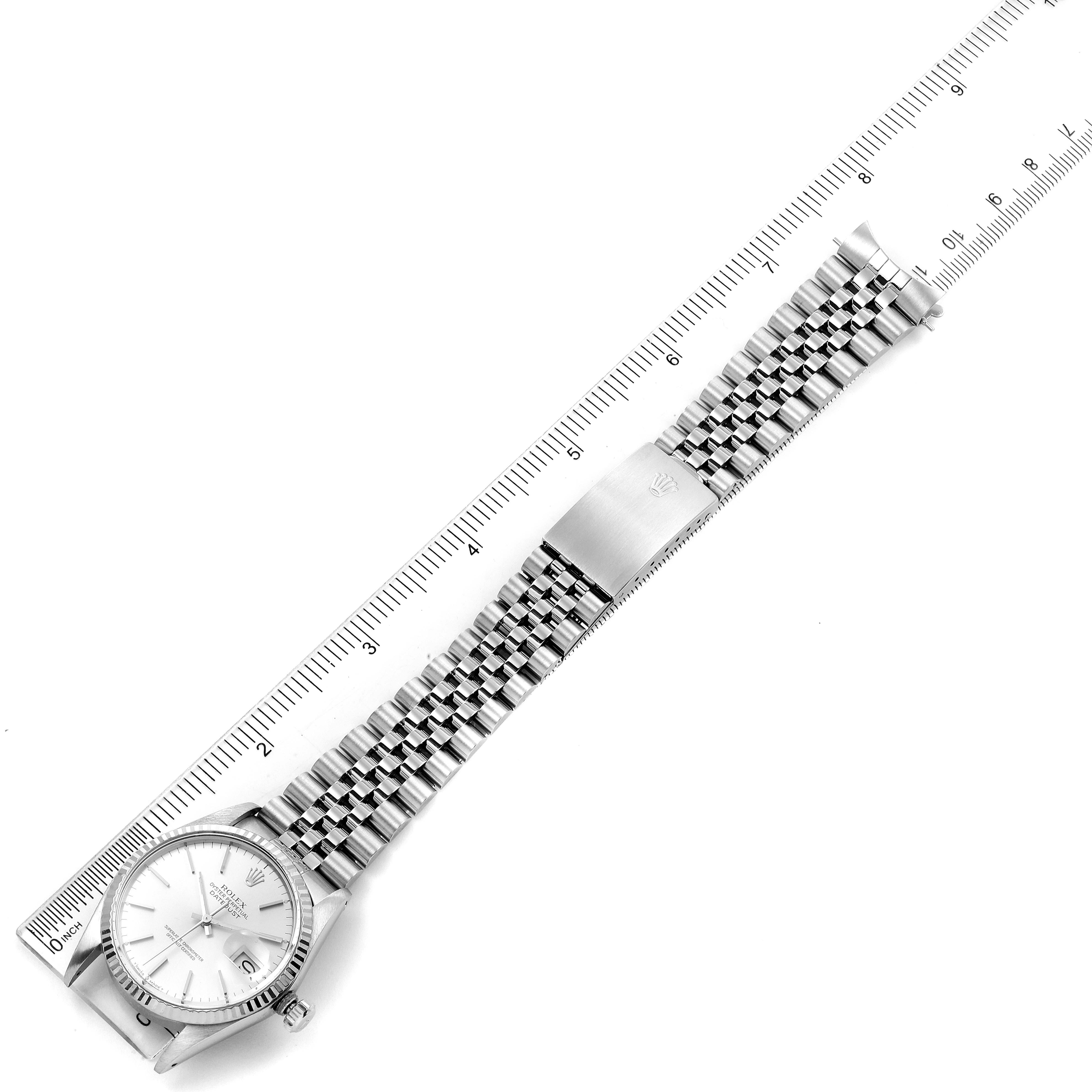 The Rolex Vintage Collection 16014 Men
s Stainless Steel Silver Dial 16014 Men
s Stainless Steel Silver Dial watch is shown from a top-down angle, displaying the face, bracelet, and clasp with a ruler for scale.