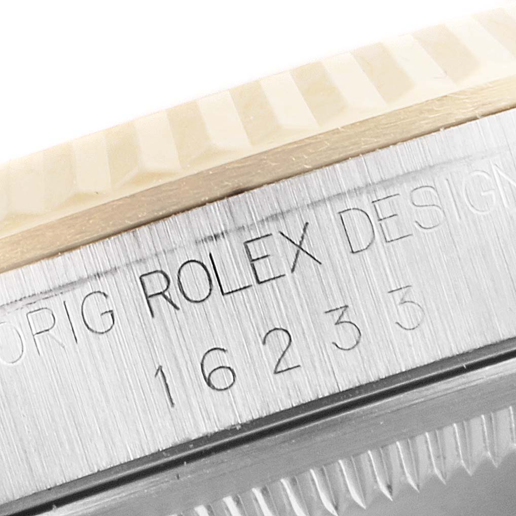 The image shows a close-up of the side of the Rolex Datejust 16233 Men's Steel and Gold (two tone) Blue Dial 16233 Men's Steel and Gold (two tone) Blue Dial watch, highlighting the engraved model number and fluted bezel.