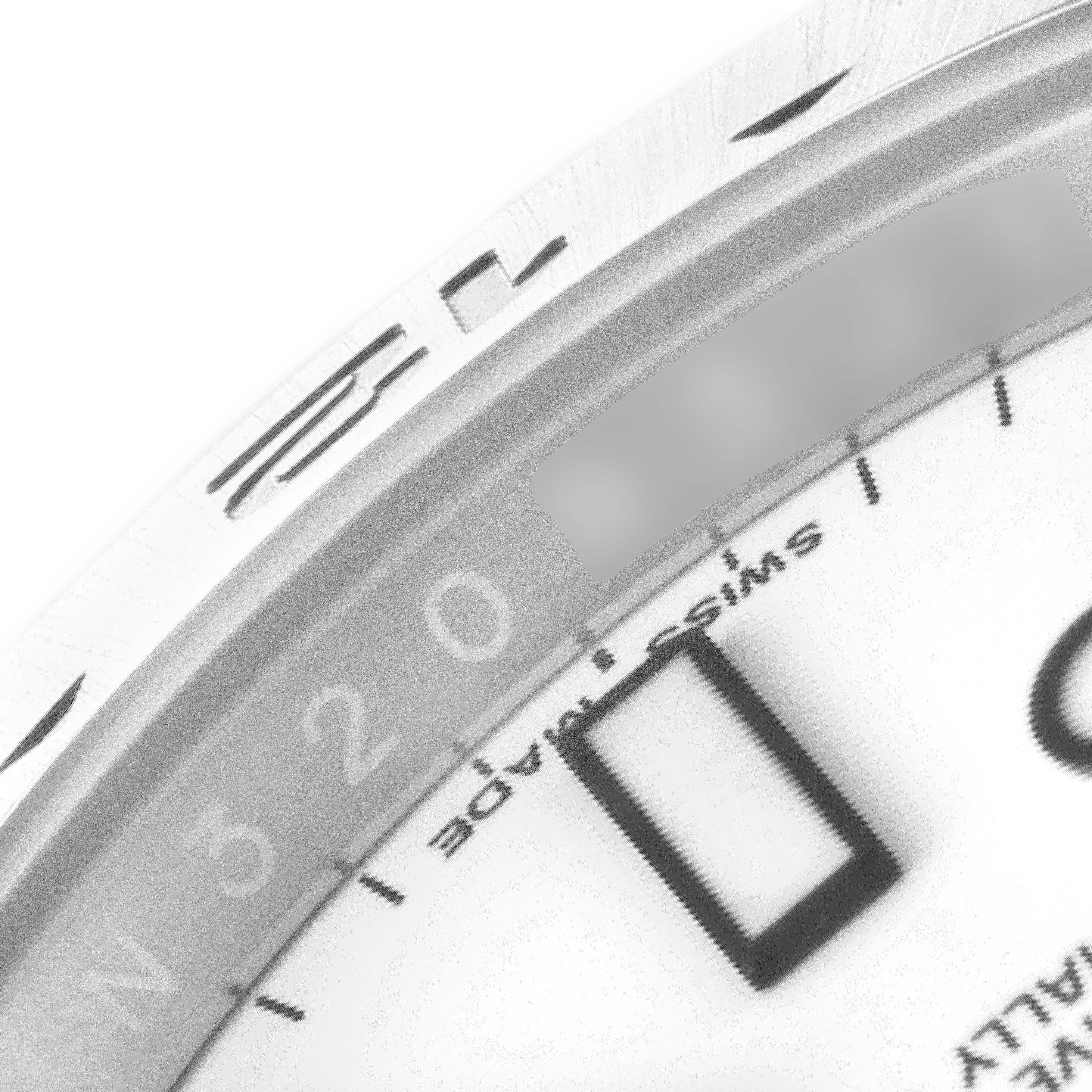 This close-up image shows the bezel and part of the dial of the Rolex Explorer 216570 Men's Stainless Steel White Dial 216570 Men's Stainless Steel White Dial watch, specifically the chapter ring and some numerals.