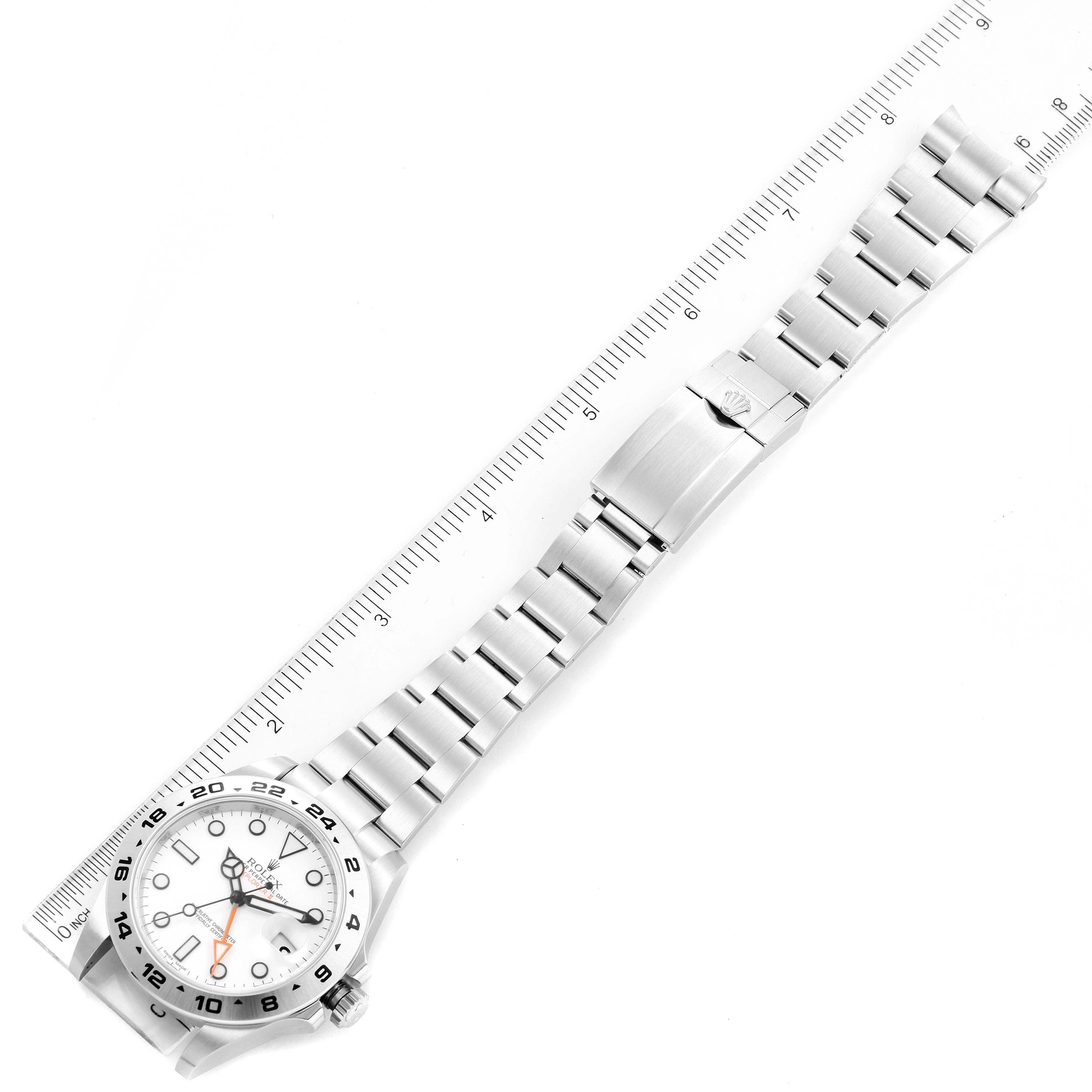 The image shows an overhead view of a Rolex Explorer 216570 Men's Stainless Steel White Dial 216570 Men's Stainless Steel White Dial watch, displaying the bracelet, clasp, and face next to a size ruler.