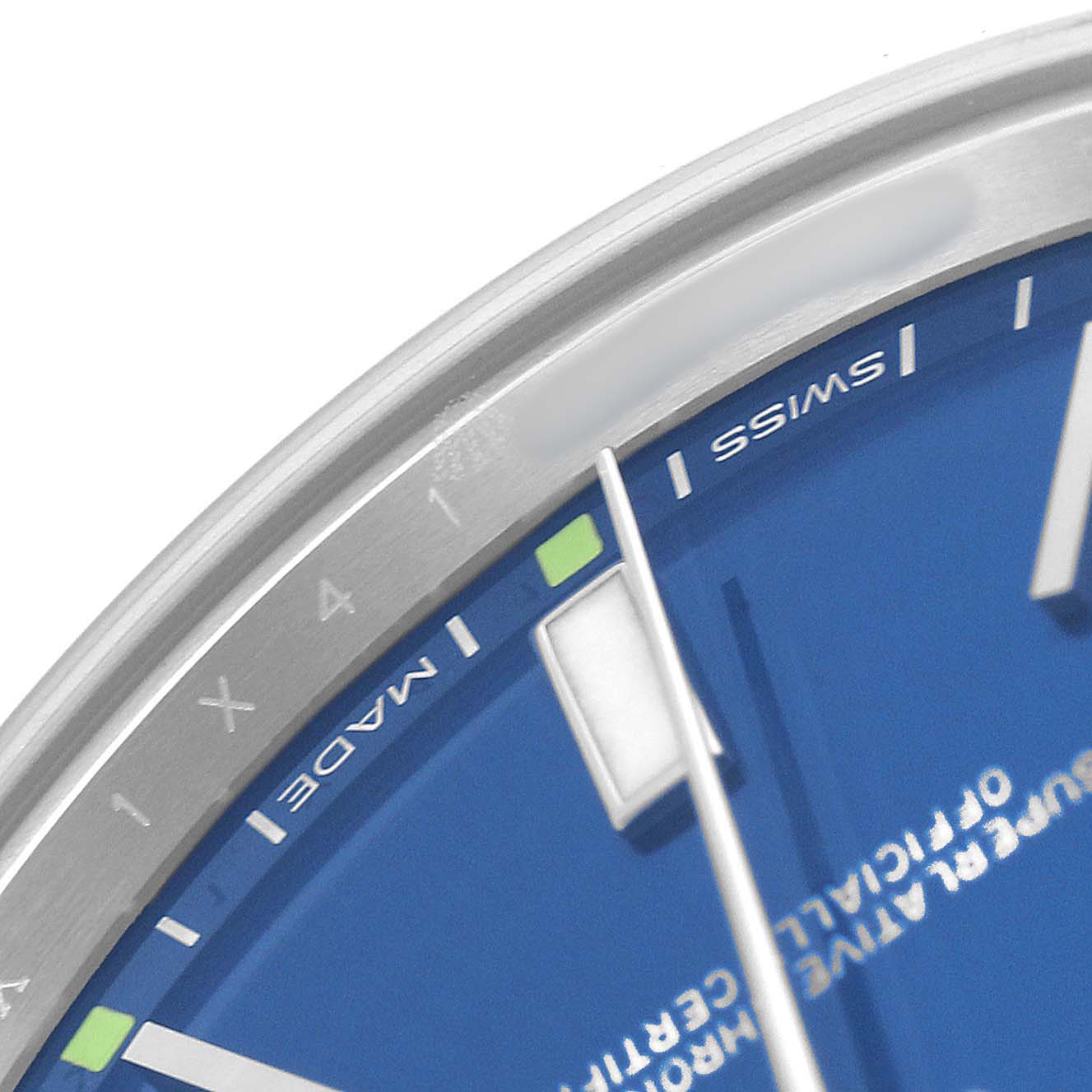 The image shows a close-up angle of a Rolex Oyster Perpetual 114300 Men's Stainless Steel Blue Dial watch face, highlighting the blue dial, markers, and hands.