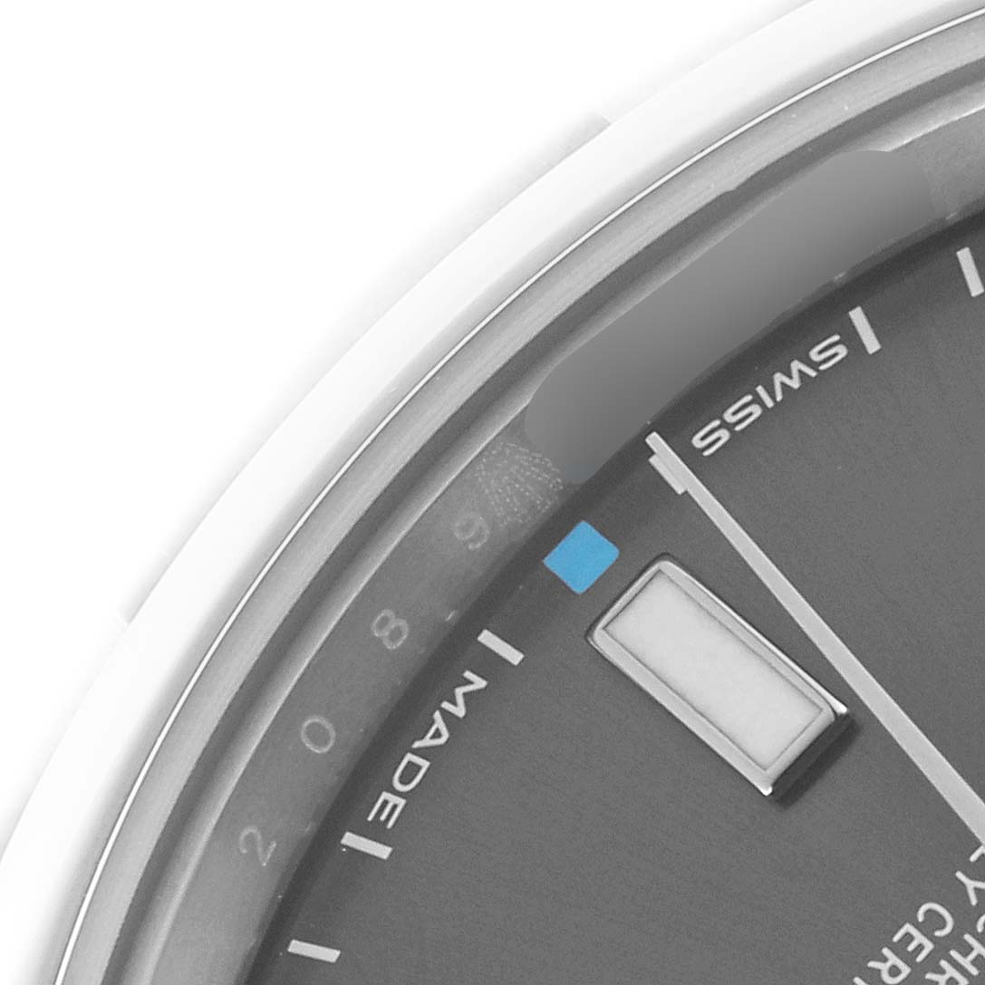 The image shows a close-up of the dial edge and hour markers of a Rolex Oyster Perpetual 114300 Men's Stainless Steel Grey Dial 114300 Men's Stainless Steel Grey Dial watch.