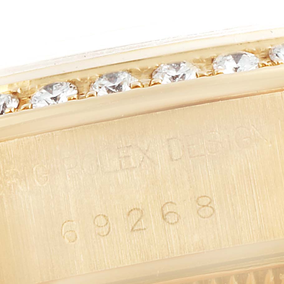 This close-up image shows the engraved serial number and part of the bezel with diamonds of a Rolex President 69268 Women's Yellow Gold Champagne Dial 69268 Women's Yellow Gold Champagne Dial model watch.