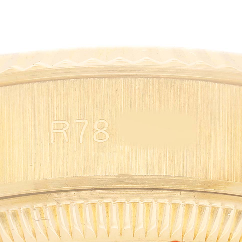 The image shows a close-up of the Rolex President 69178 Women's Yellow Gold Champagne Dial model's gold bezel with engraved lettering.