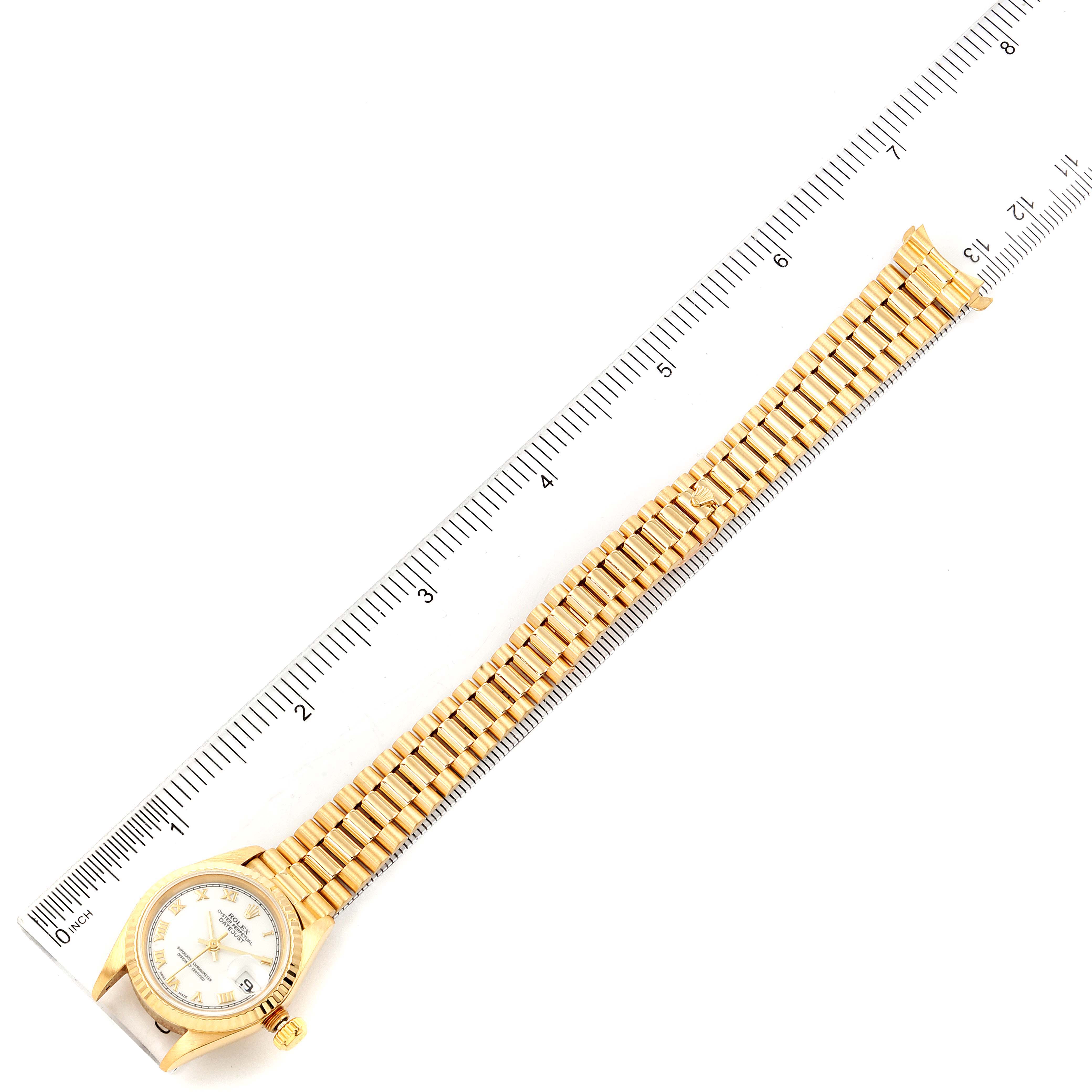 Top view of a Rolex President 69178 Women
s Yellow Gold White Dial 69178 Women
s Yellow Gold White Dial model watch showing the entire band and face, placed alongside a measuring ruler.