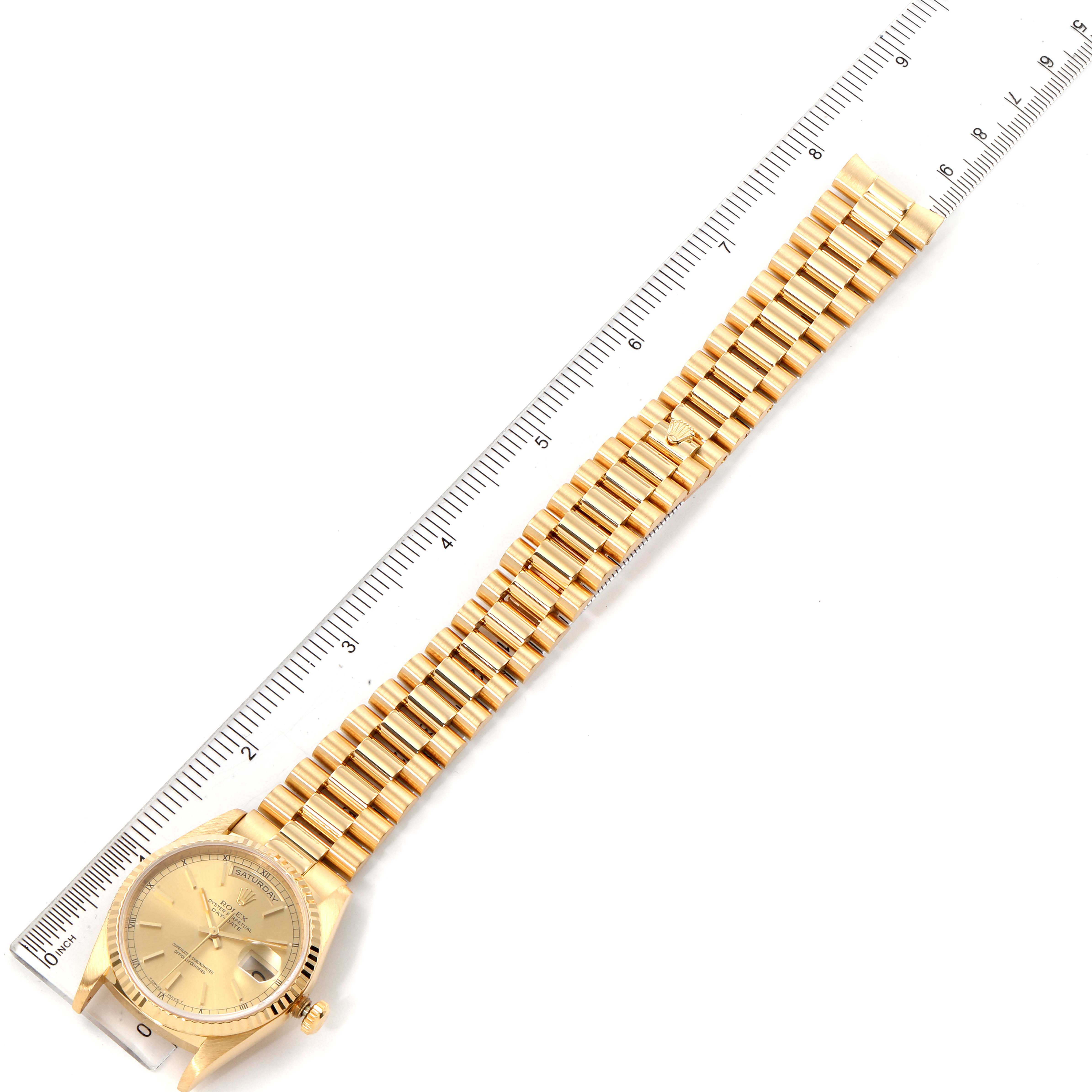 The image shows a Rolex President 18238 Men's Yellow Gold Champagne Dial 18238 Men's Yellow Gold Champagne Dial model watch laid flat next to a ruler, highlighting the watch face and full bracelet.