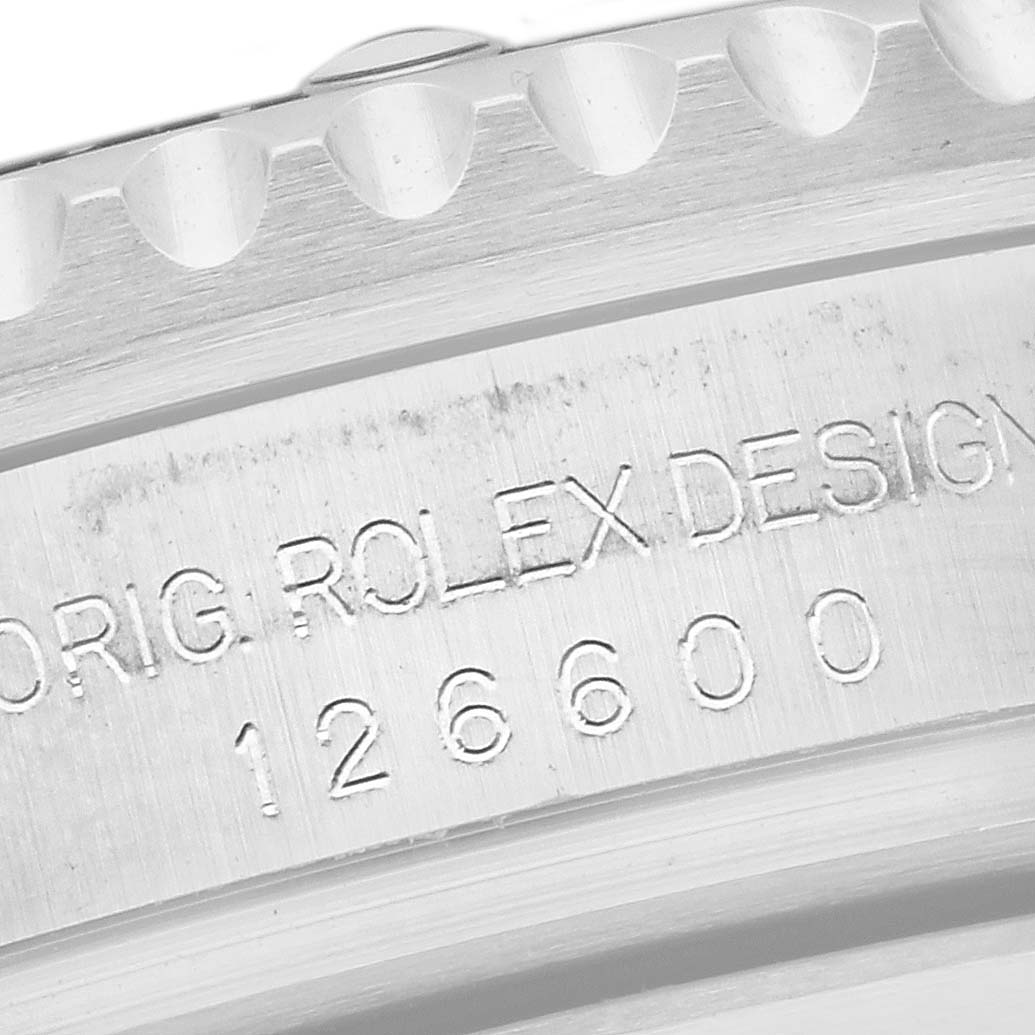 The image shows a close-up of the Rolex Sea-Dweller 126600 Men's Stainless Steel Black Dial 126600 Men's Stainless Steel Black Dial's engraved bezel and model number 126600.