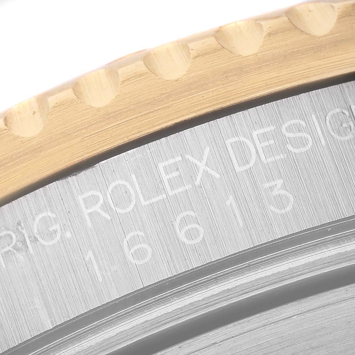 This close-up image of a Rolex Submariner 16613 Men's Steel and Gold (two tone) Blue Dial 16613 Men's Steel and Gold (two tone) Blue Dial shows part of the bezel and engraved case back model number "16613".