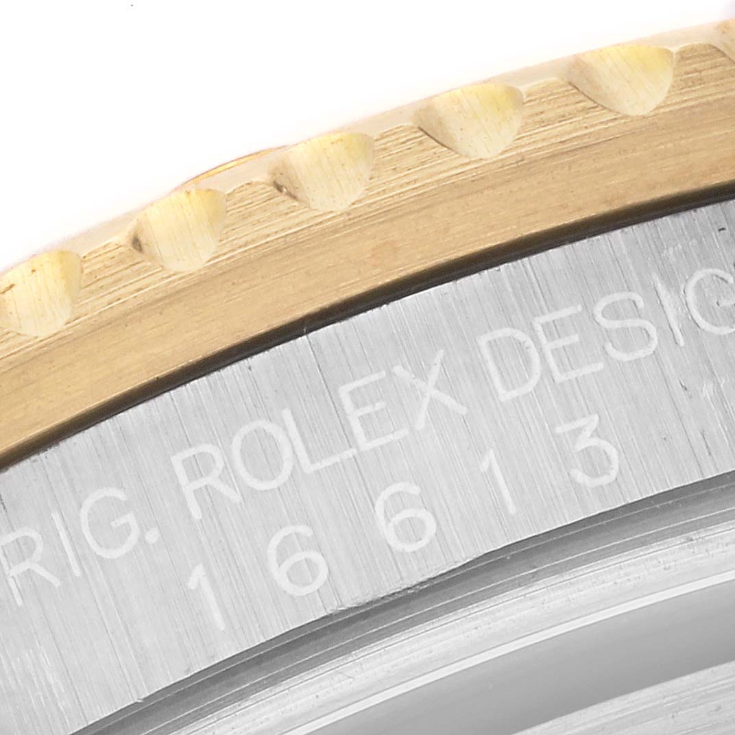 Close-up of the bezel and part of the case side of a Rolex Submariner 16613LB Men's Steel and Gold (two tone) Champagne Dial 16613LB Men's Steel and Gold (two tone) Champagne Dial watch, showing the engraved model number 16613.