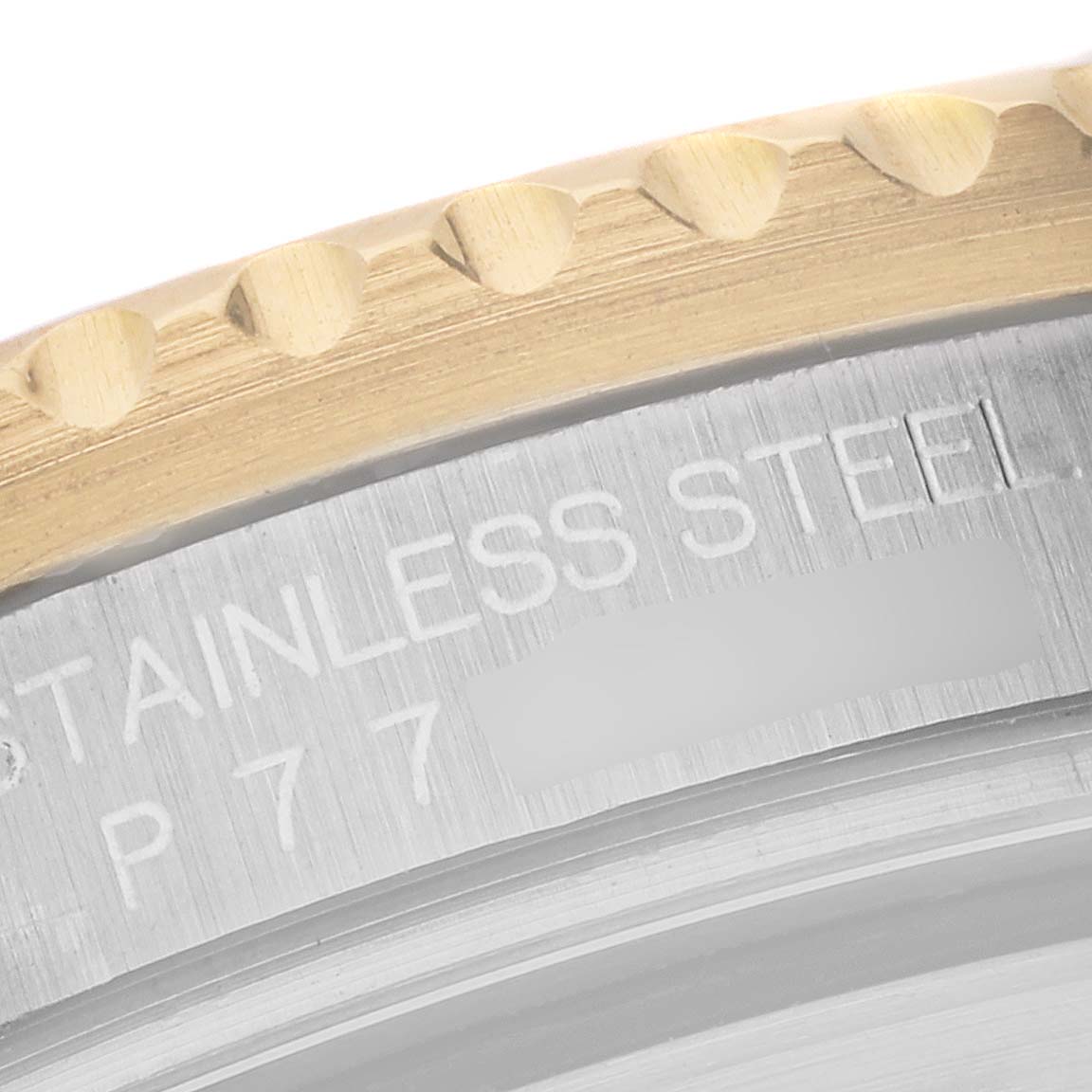 This close-up angle shows the engraved text "STAINLESS STEEL" along with part of the bezel of a Rolex Submariner 16613LB Men's Steel and Gold (two tone) Champagne Dial 16613LB Men's Steel and Gold (two tone) Champagne Dial watch.