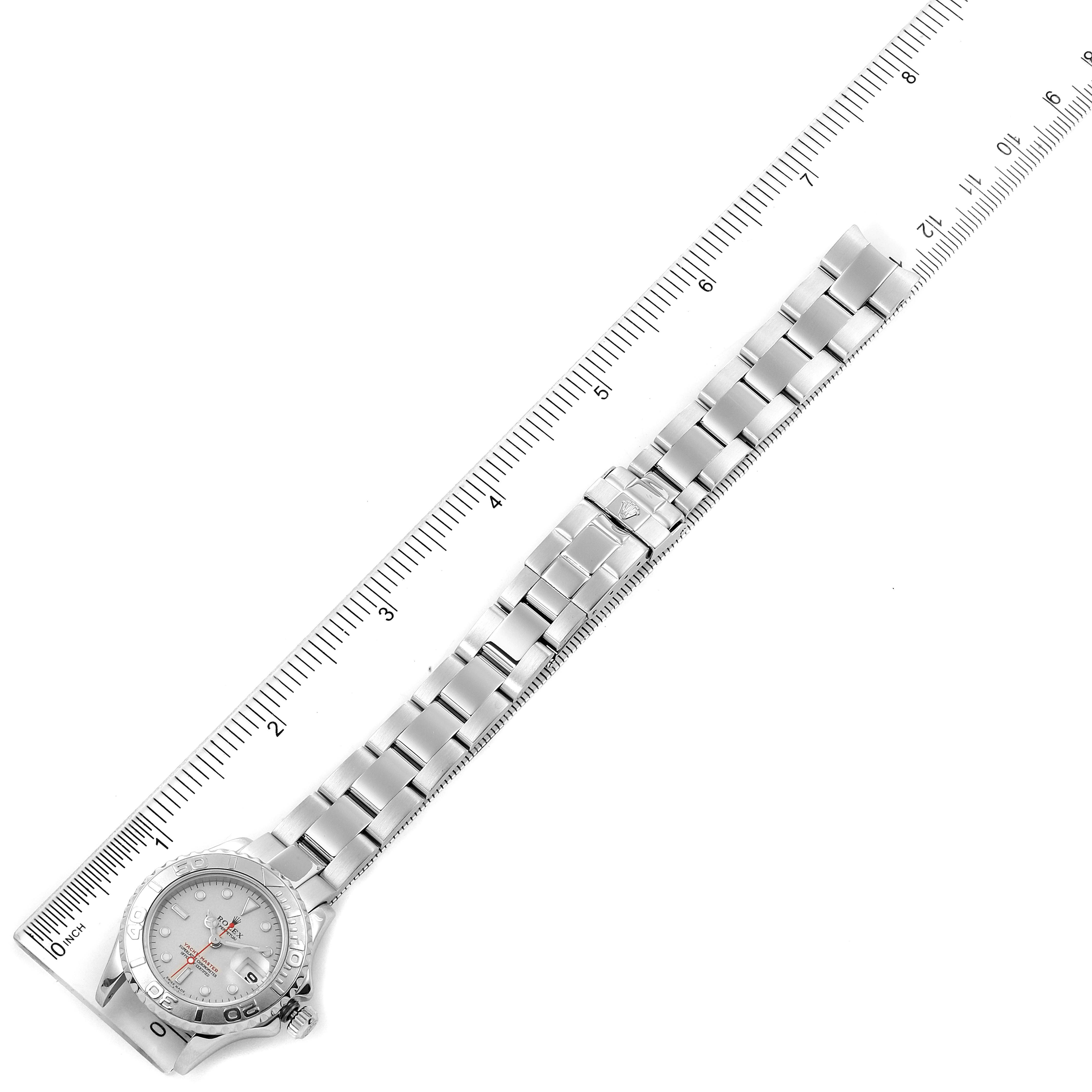 The Rolex Yacht-Master 169622 Women's Stainless Steel Silver Dial 169622 Women's Stainless Steel Silver Dial watch is shown from a top-down angle, highlighting the face, bracelet, and a measuring ruler.