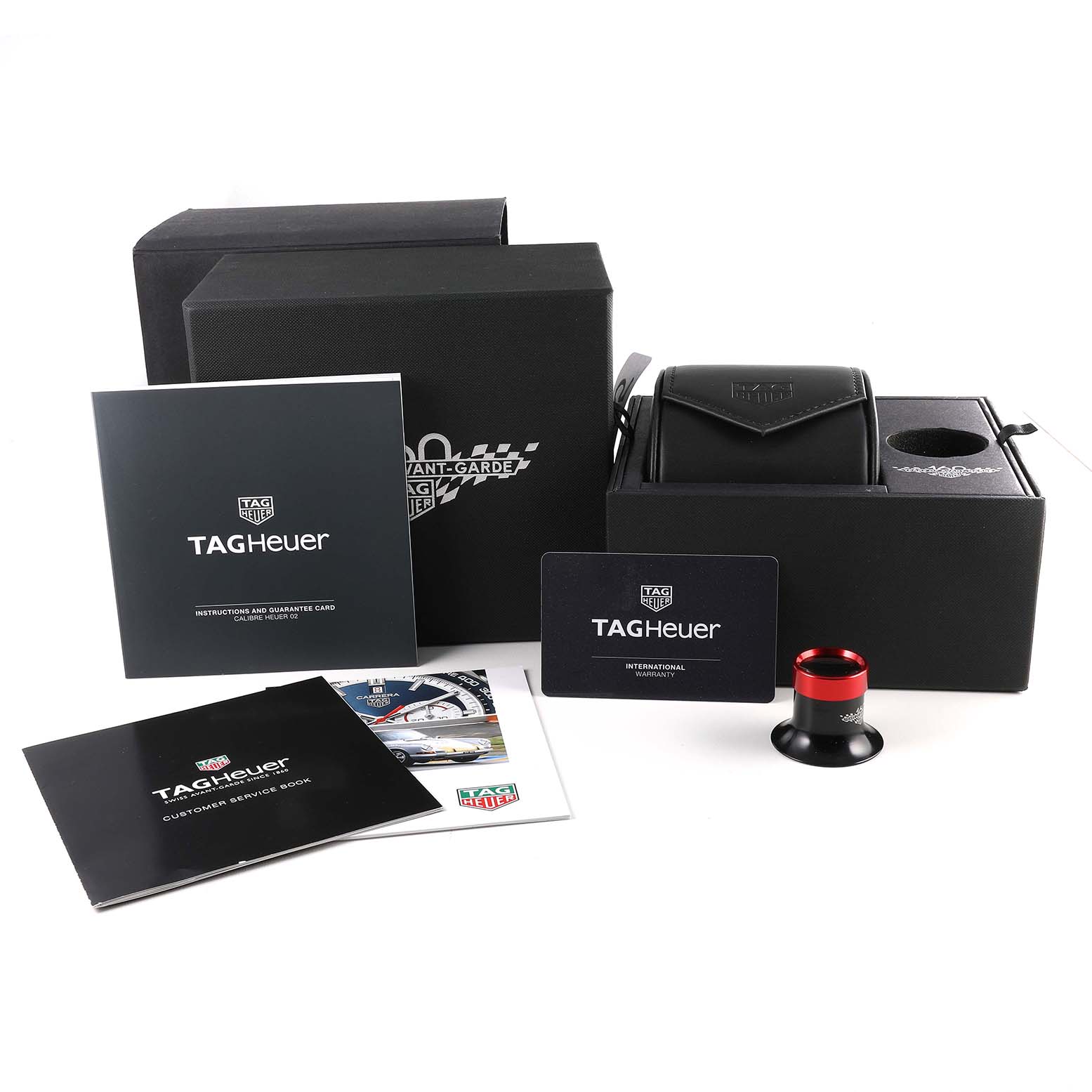 The image shows the packaging and accessories for the Tag Heuer Carrera CBN2A1E Men's Stainless Steel Blue Dial CBN2A1E Men's Stainless Steel Blue Dial model, including booklets, a guarantee card, and a black watch case.
