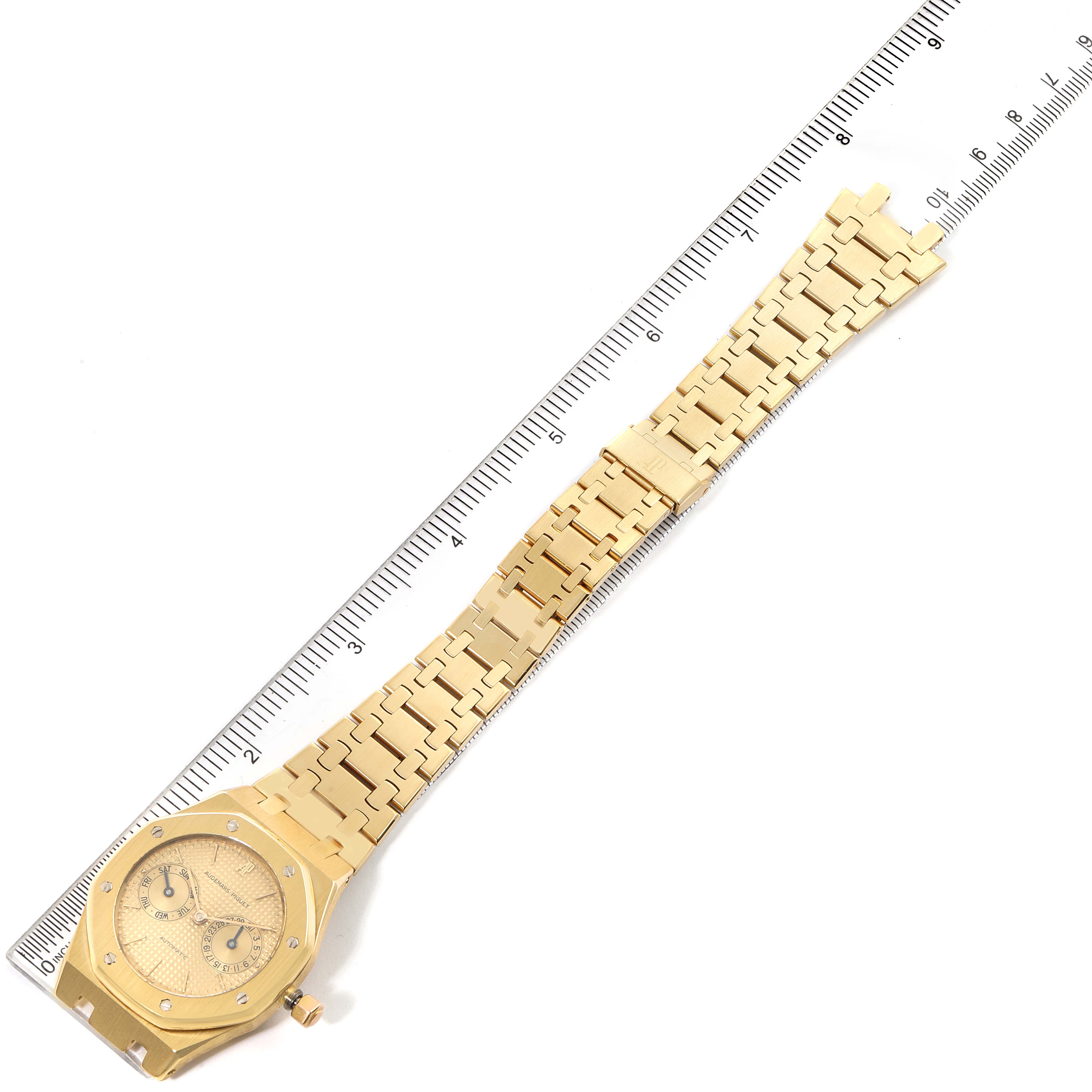 The image shows a gold Audemars Piguet Royal Oak 25572BA.0.0477BA.01 Men's Yellow Gold Champagne Dial 25572BA.0.0477BA.01 Men's Yellow Gold Champagne Dial watch laid flat, with its face and bracelet fully visible alongside a ruler for scale.