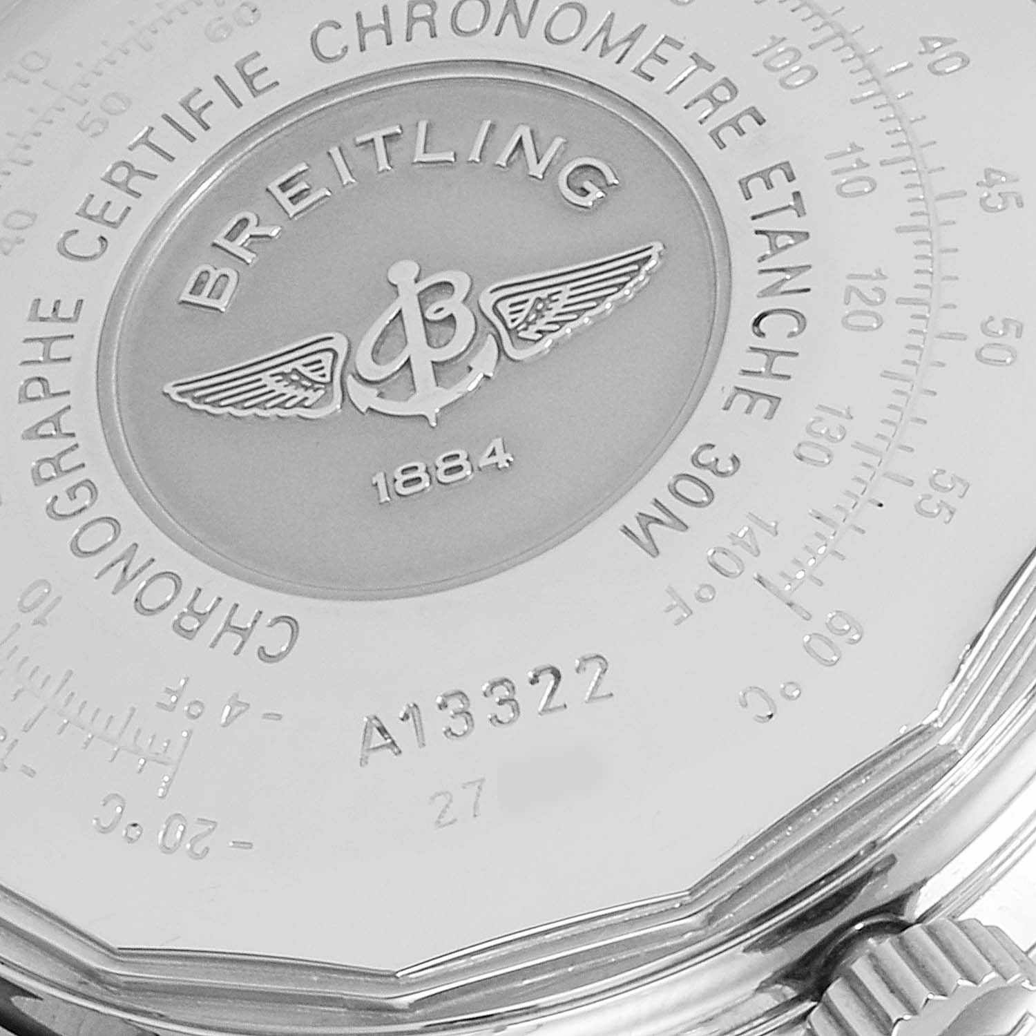 This image shows a close-up of the back case and crown of a Breitling Navitimer A13322 Men's Stainless Steel Black Dial A13322 Men's Stainless Steel Black Dial watch, highlighting its engravings and logo.