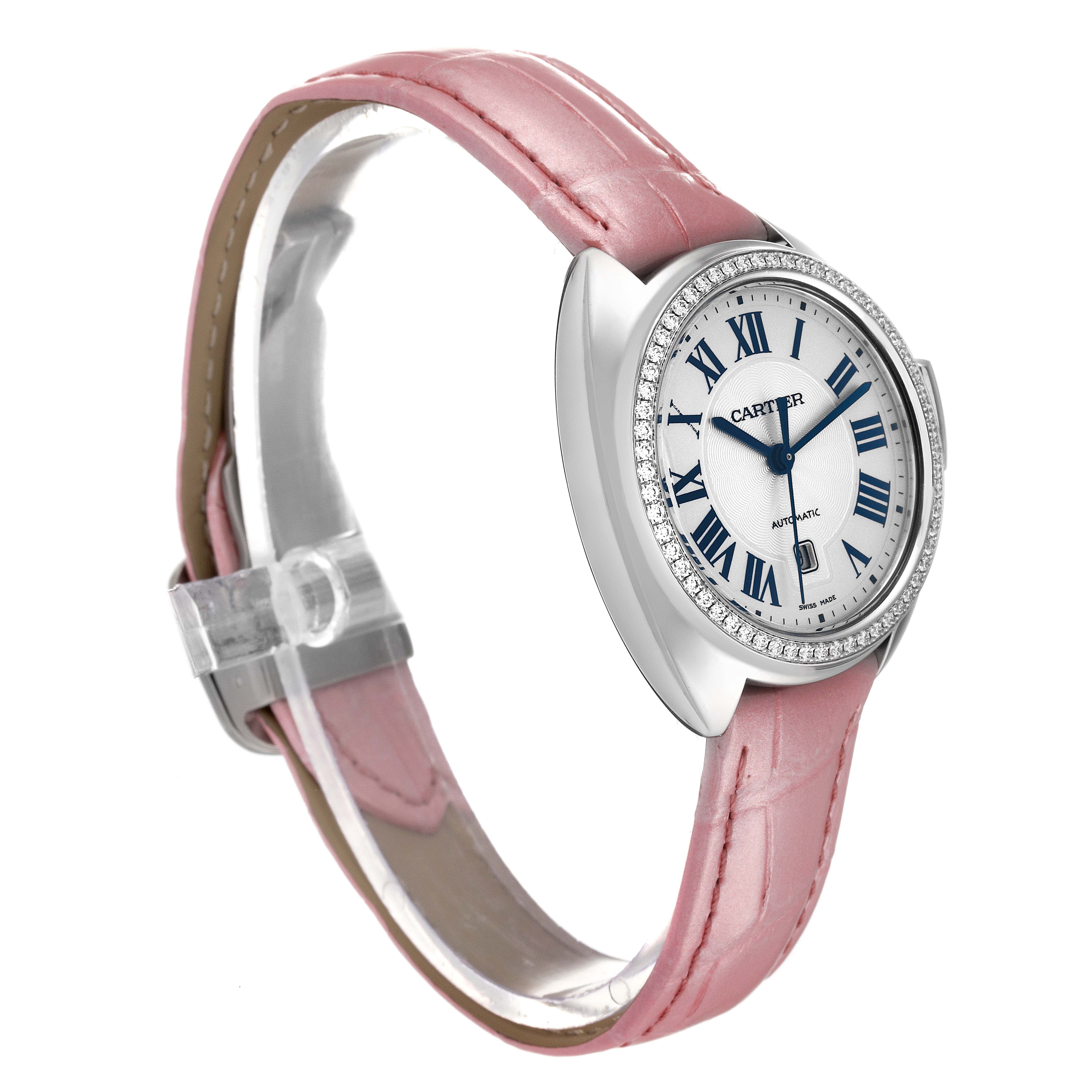 The image shows a Cartier Cle W4CL0005 Women's Stainless Steel Blue Dial W4CL0005 Women's Stainless Steel Blue Dial model watch at an angled view, displaying the pink strap, silver case, and dial with Roman numerals.