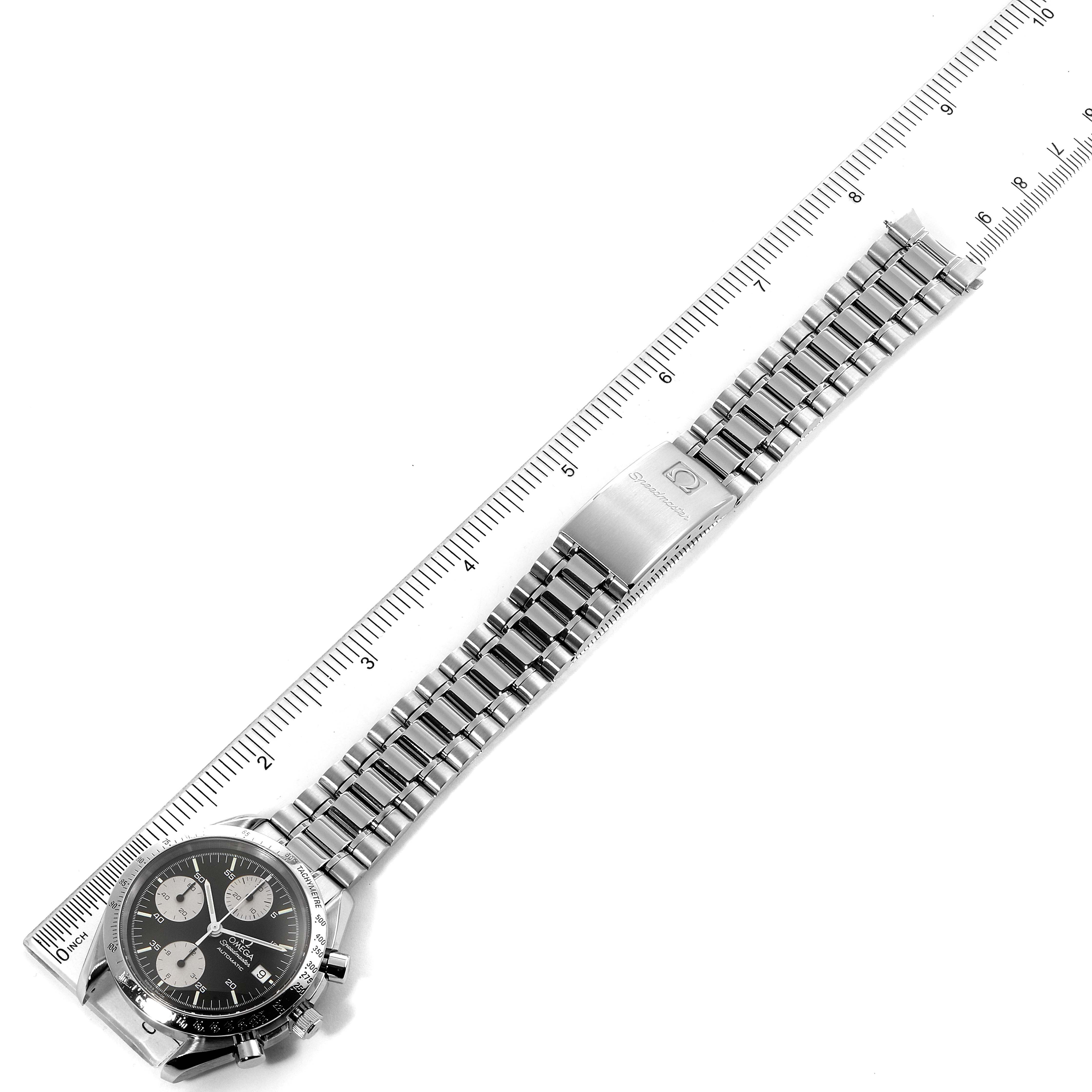 The image shows an Omega Speedmaster 3511.50.00 Men
s Stainless Steel Black Dial 3511.50.00 Men
s Stainless Steel Black Dial watch laying flat with a steel bracelet visible and a ruler for scale.