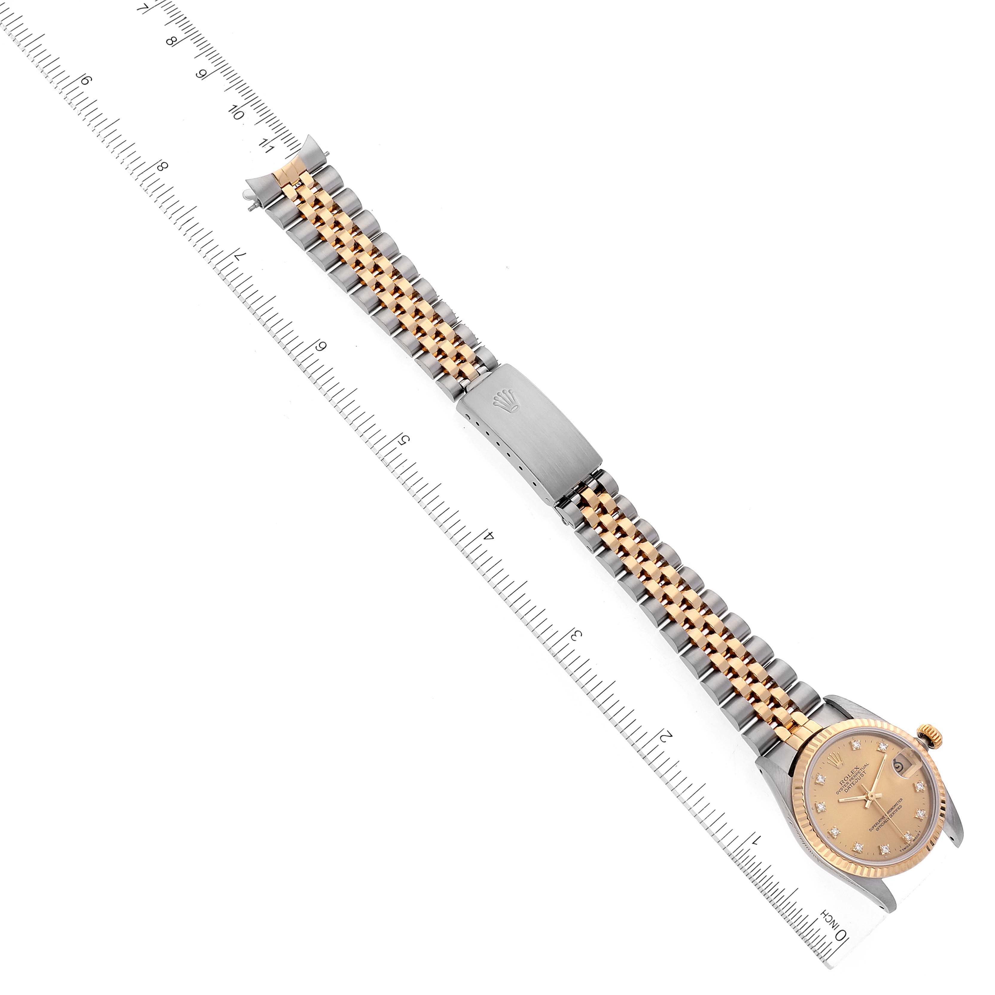 The image shows a Rolex Mid-Size 68273 Women
s Steel and Gold (two tone) Champagne Dial 68273 Women
s Steel and Gold (two tone) Champagne Dial watch laid flat with its entire band and face visible, positioned next to a ruler.