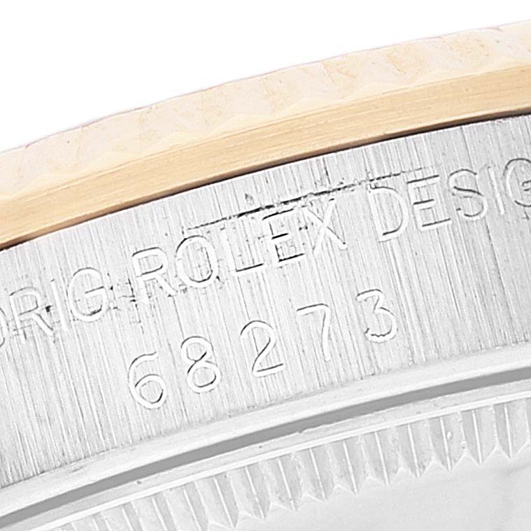 The image shows a close-up of the side of a Rolex Mid-Size 68273 Women
s Steel and Gold (two tone) Champagne Dial 68273 Women
s Steel and Gold (two tone) Champagne Dial watch case, highlighting the engraved model number 68273.
