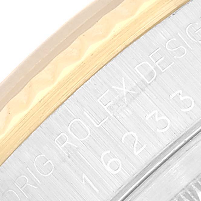 Close-up of the outer rim of a Rolex Datejust 16233 Men's Steel and Gold (two tone) Champagne Dial 16233 Men's Steel and Gold (two tone) Champagne Dial watch, showing part of the engraved text and serial number.