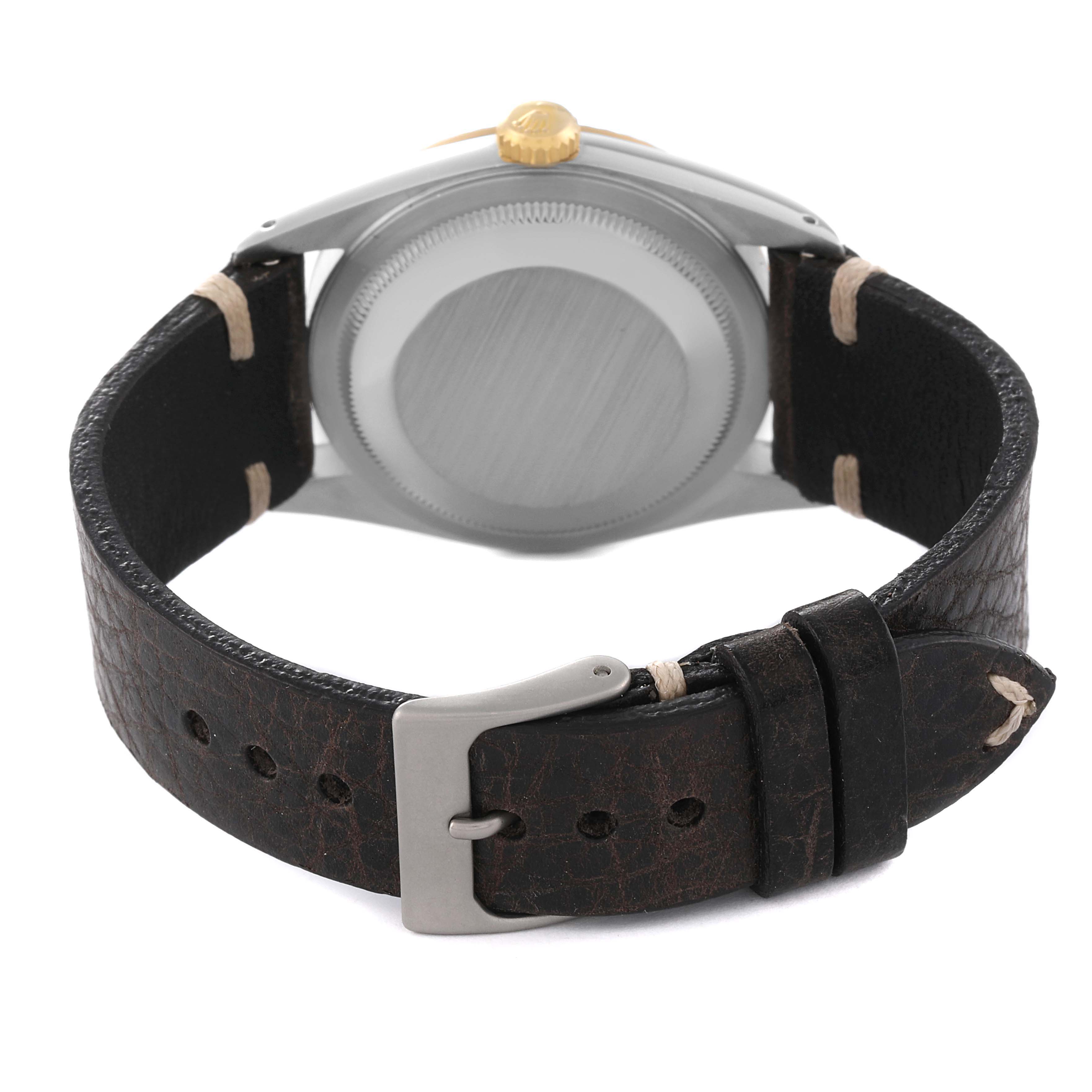 The image shows the back view of a Rolex Datejust 16233 Men's Steel and Gold (two tone) Champagne Dial 16233 Men's Steel and Gold (two tone) Champagne Dial watch with a black leather strap and metal buckle.