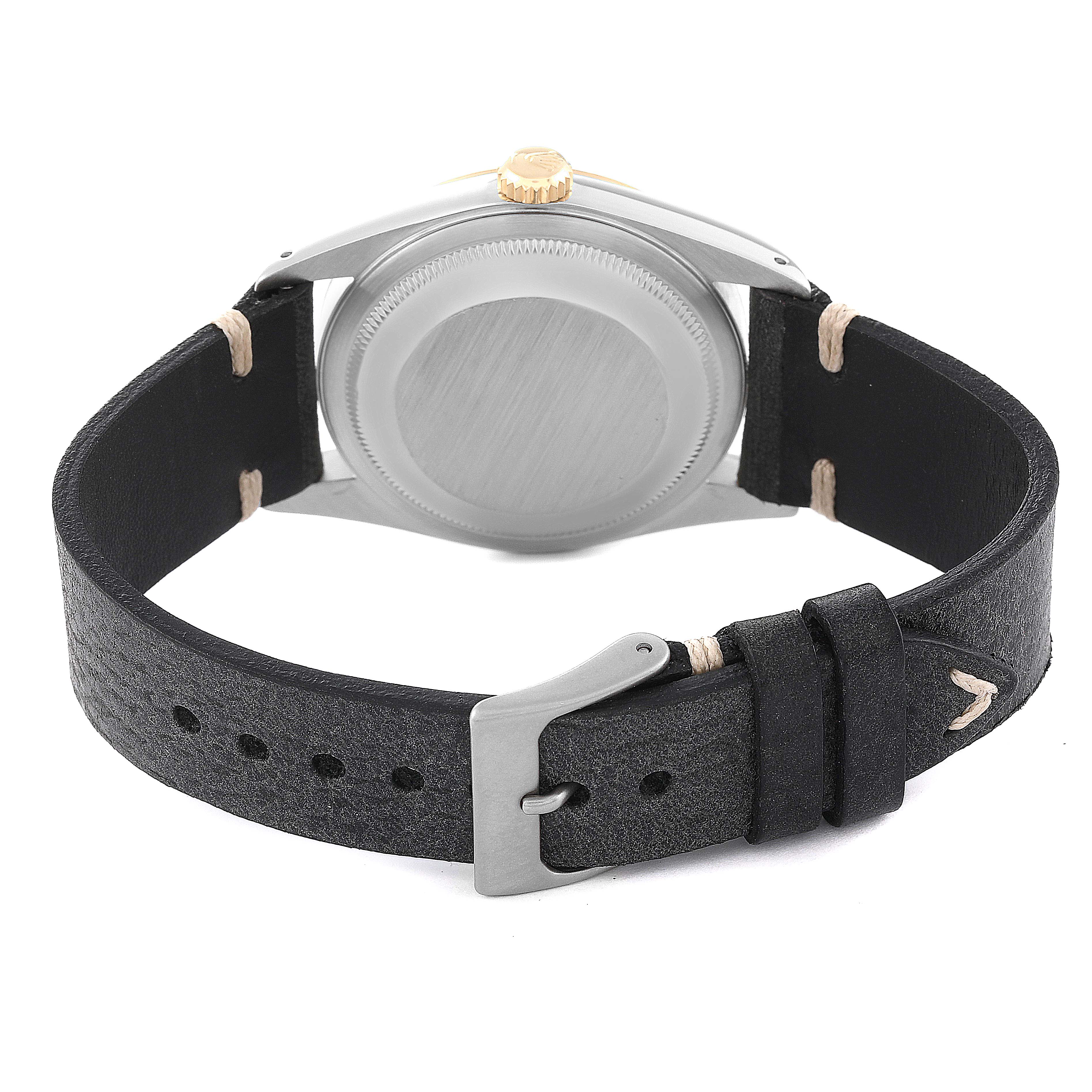 The image shows the back of a Rolex Datejust 16233 Men's Steel and Gold (two tone) Champagne Dial 16233 Men's Steel and Gold (two tone) Champagne Dial watch with a black leather strap and a buckle.